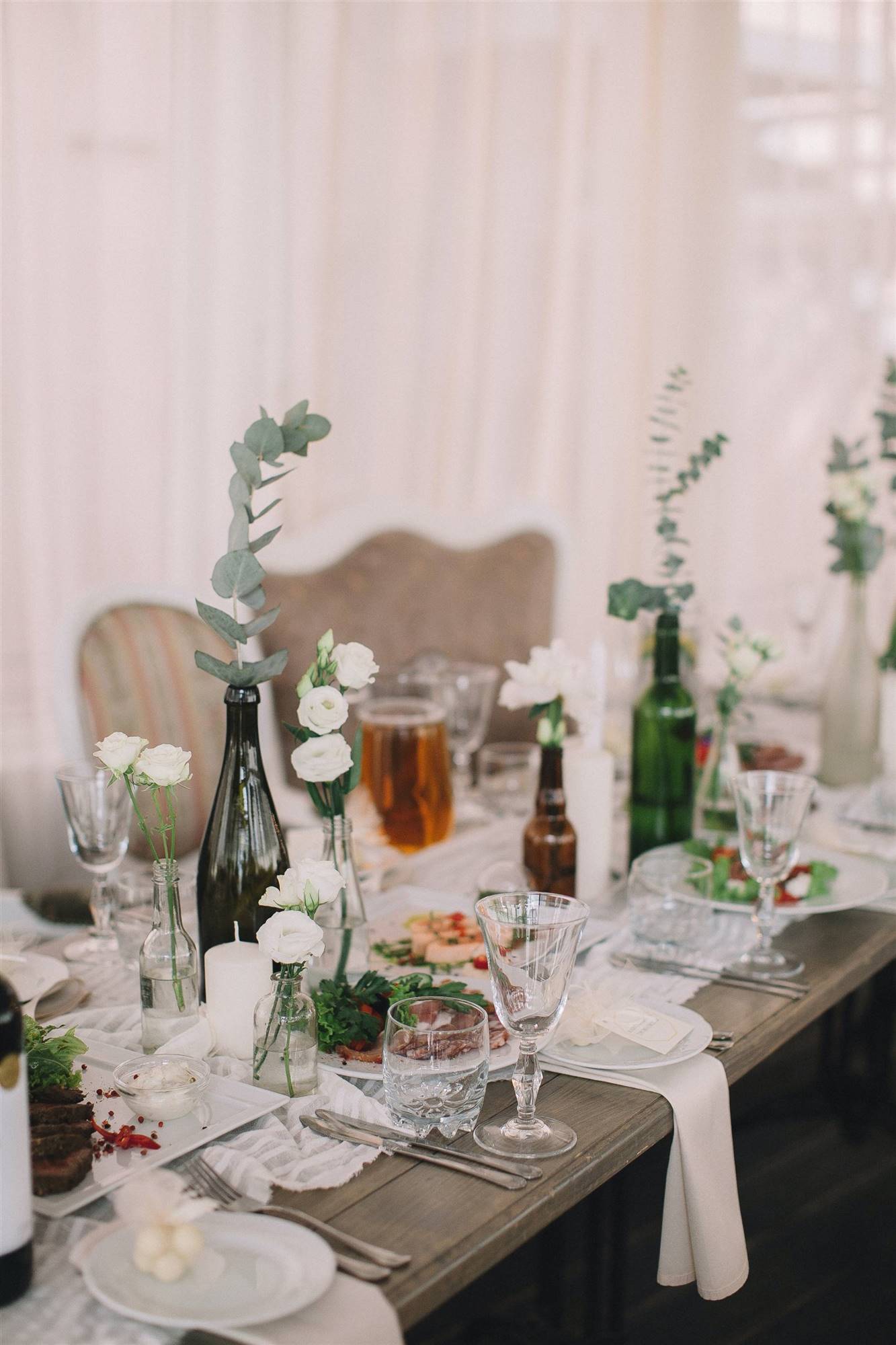 Decorar mesas de boda con botellas de cristal.