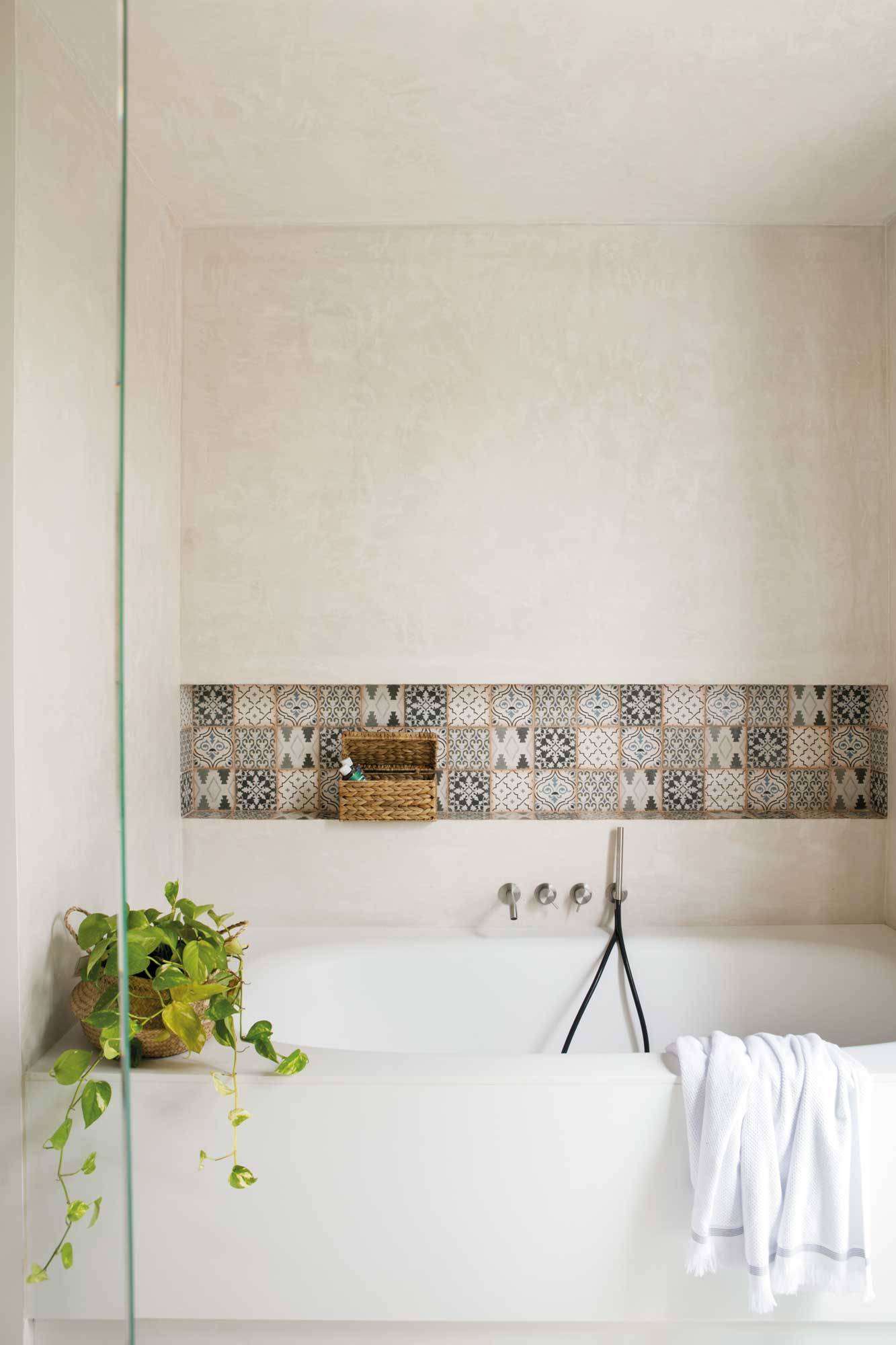 Baño con paredes de microcemento y hornacina con azulejos hidráulicos.
