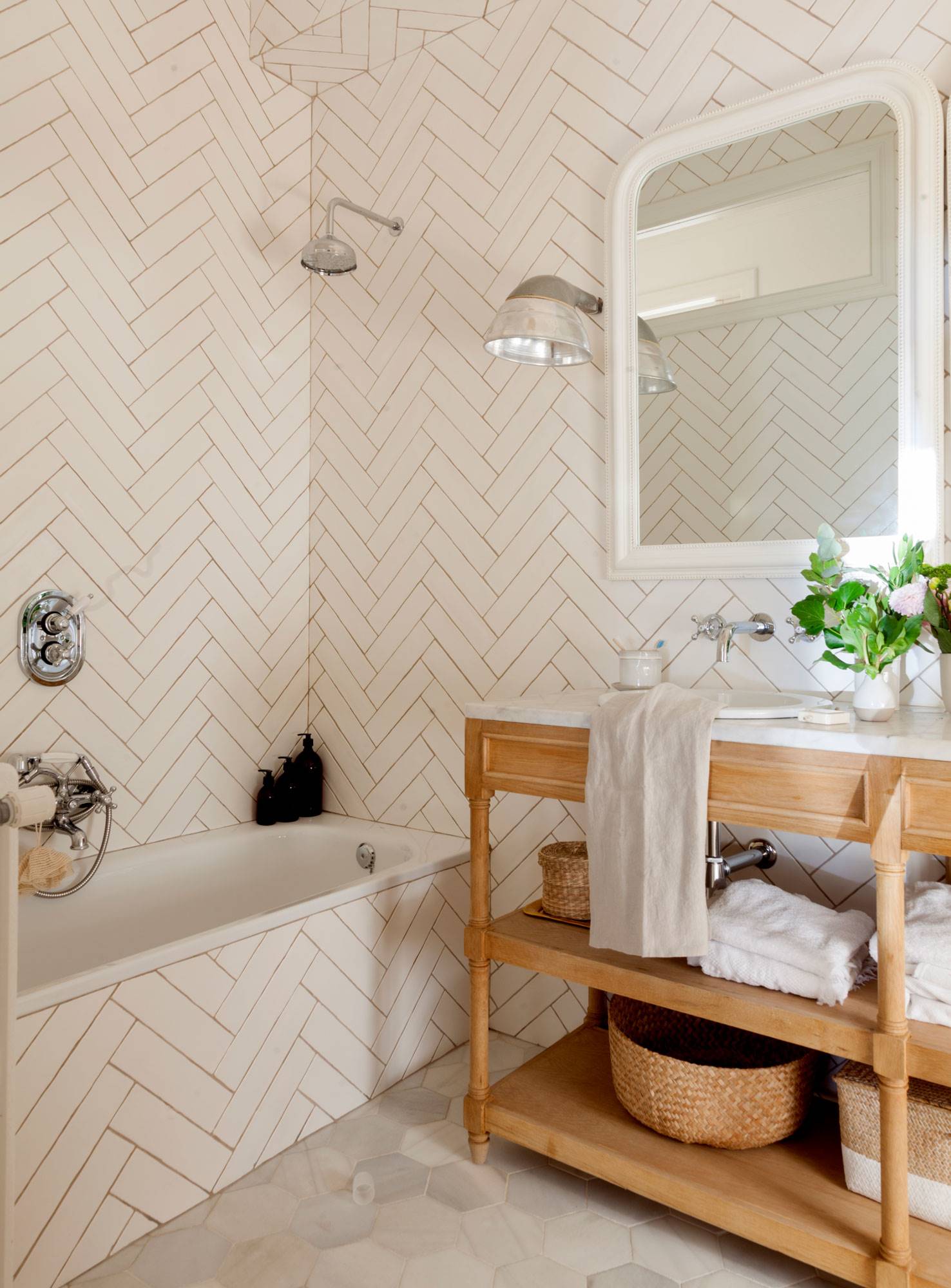 Baño con bañera y azulejos blancos con acabado brillo colocados en espiga. 