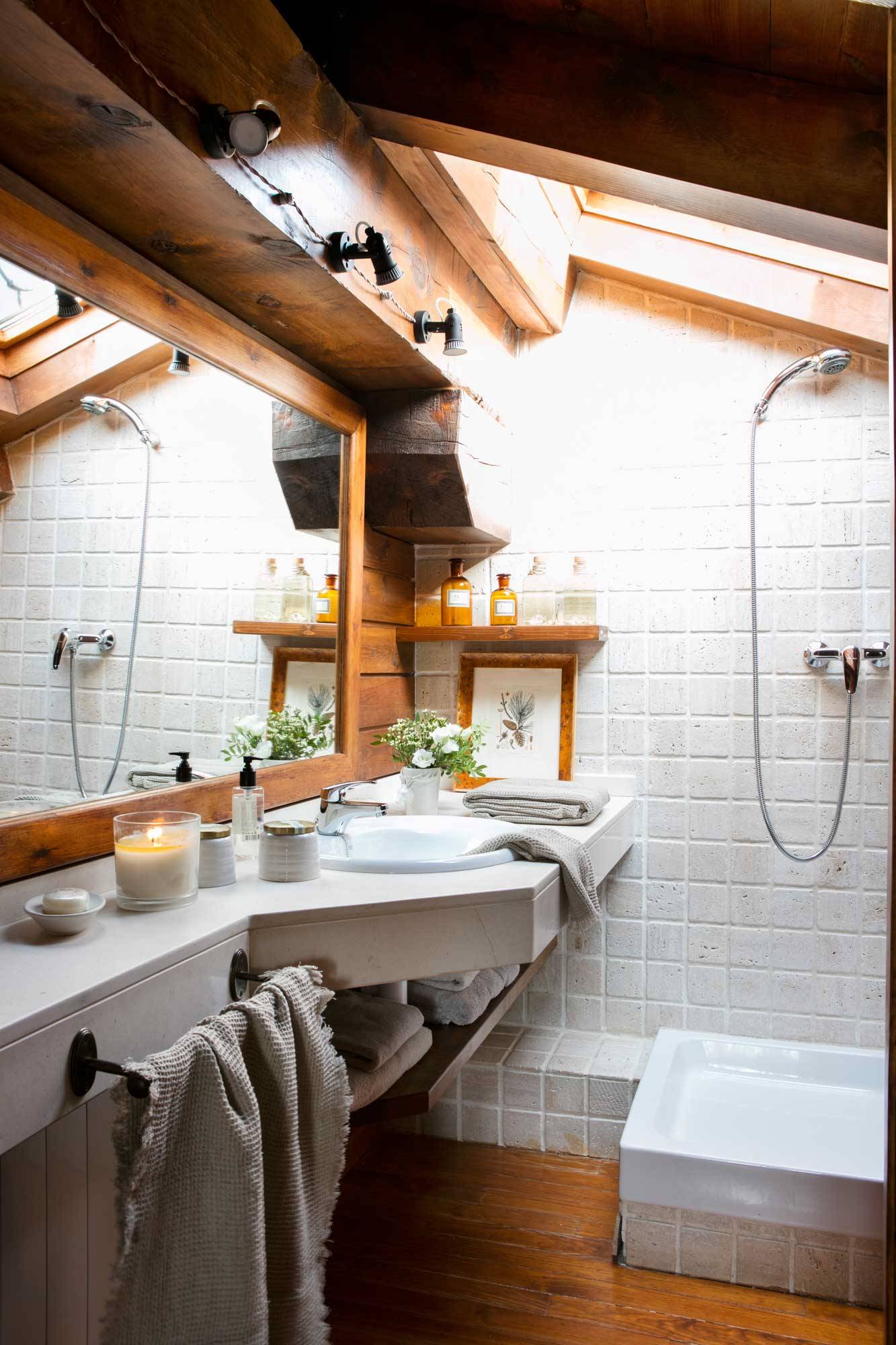 Baño rústico abuhardillado con techo de madera y paredes revestidas con azulejos blancos. 