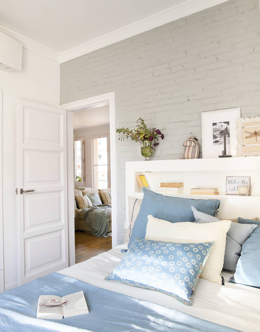 Dormitorio en gris y azul con puerta blanca con cuarterones.