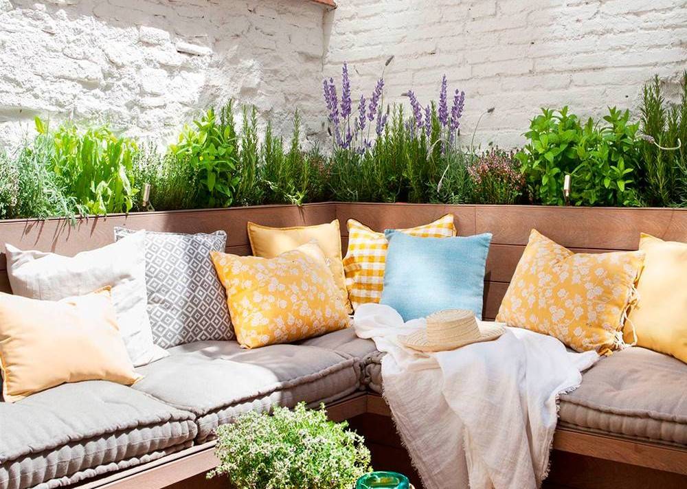 Terraza con jardín silvestre detrás del sofá.