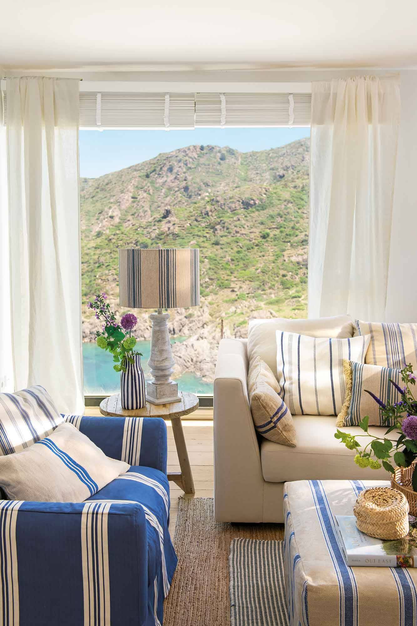 Salón veraniego con sofás que combinan tonos neutros y azules. 