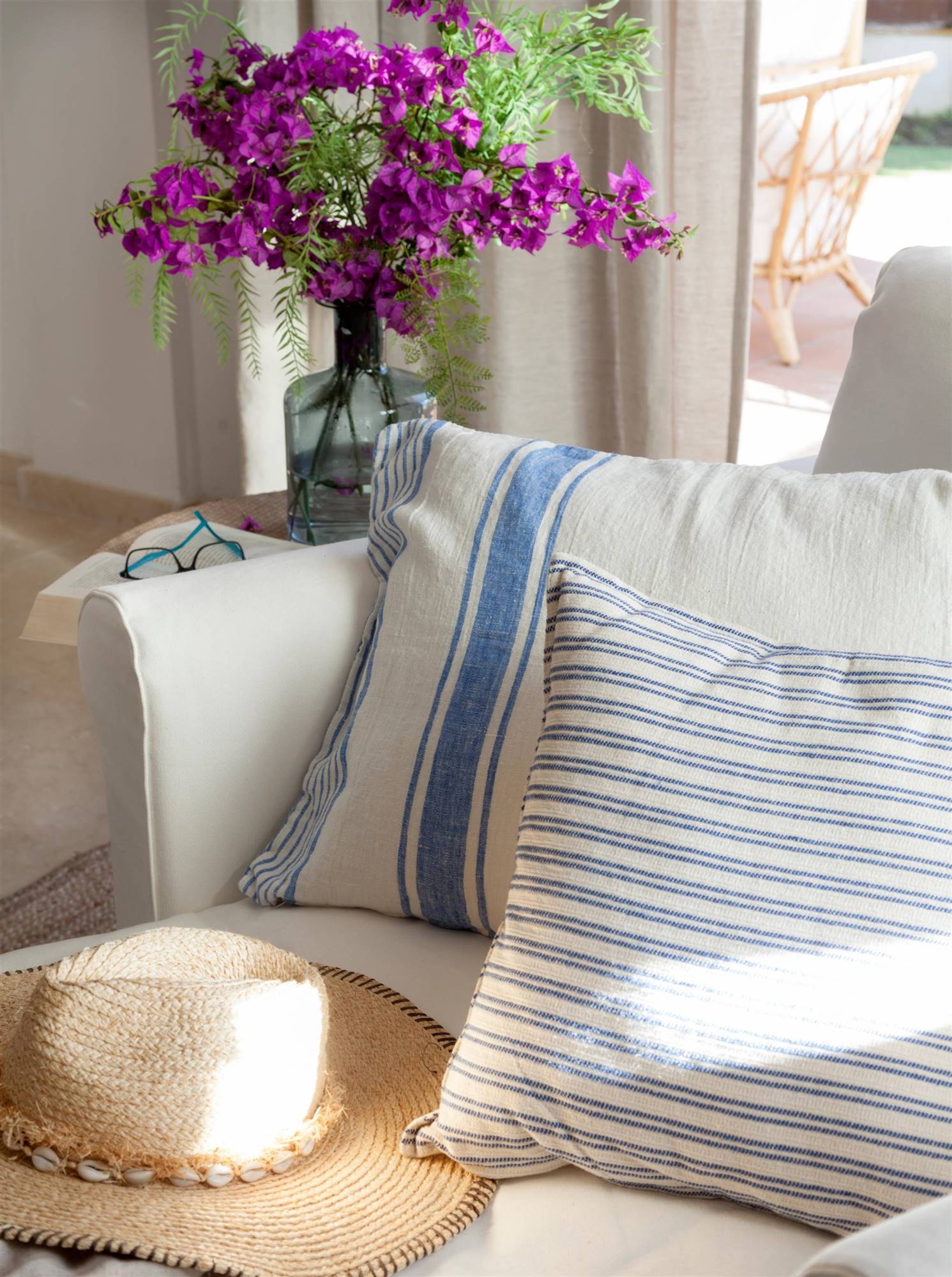 Sofá blanco con cojines con distintos estampados en blanco y azul. 