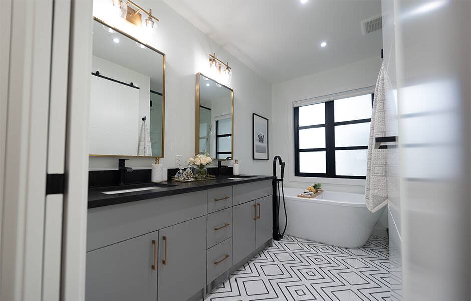 Baño con espejos dorados, bañera y azulejos geométricos, reformado por Jonathan y Drew Scott.
