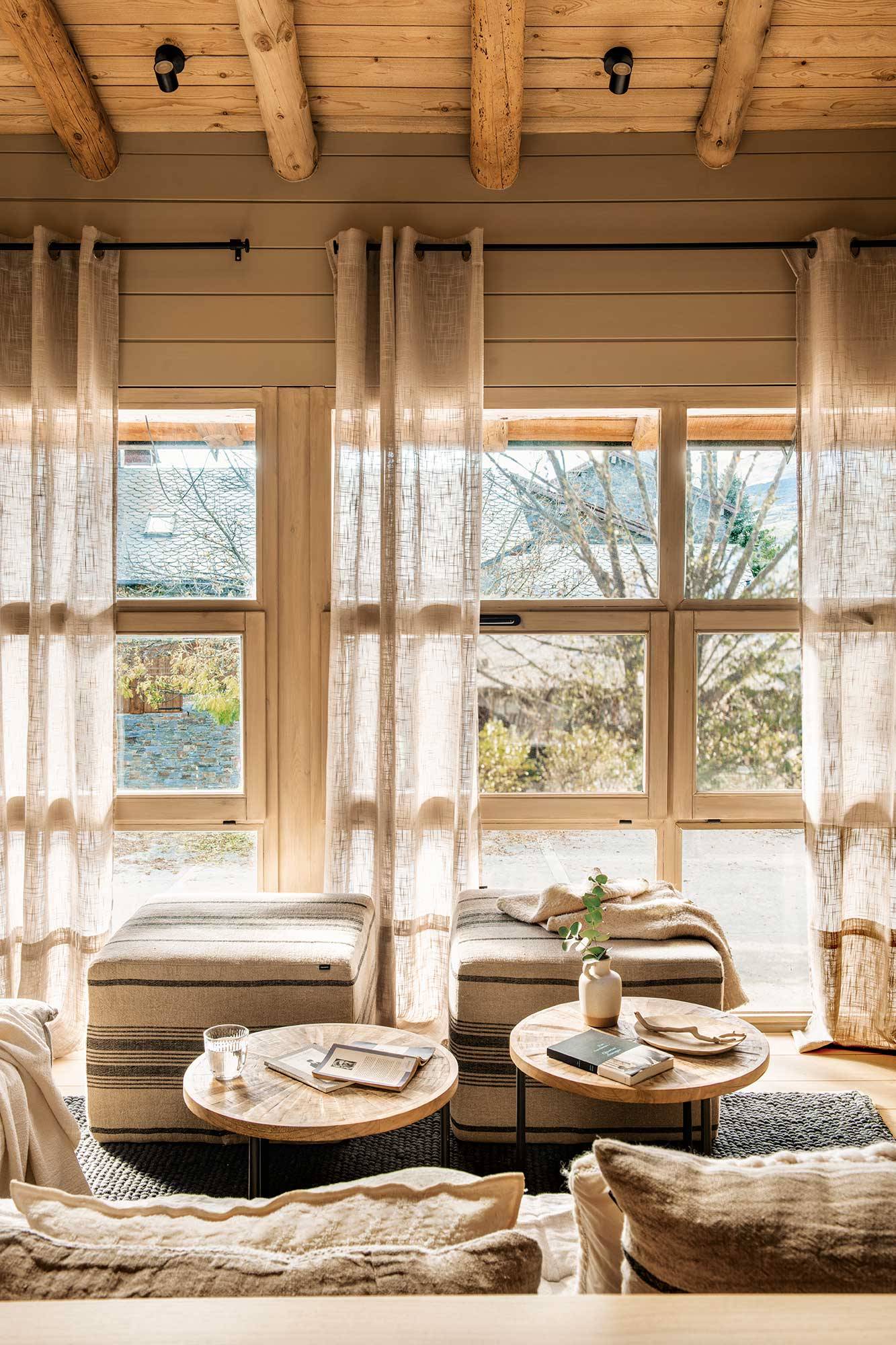 Salón con cortinas de lino semitransparentes en color beige. 