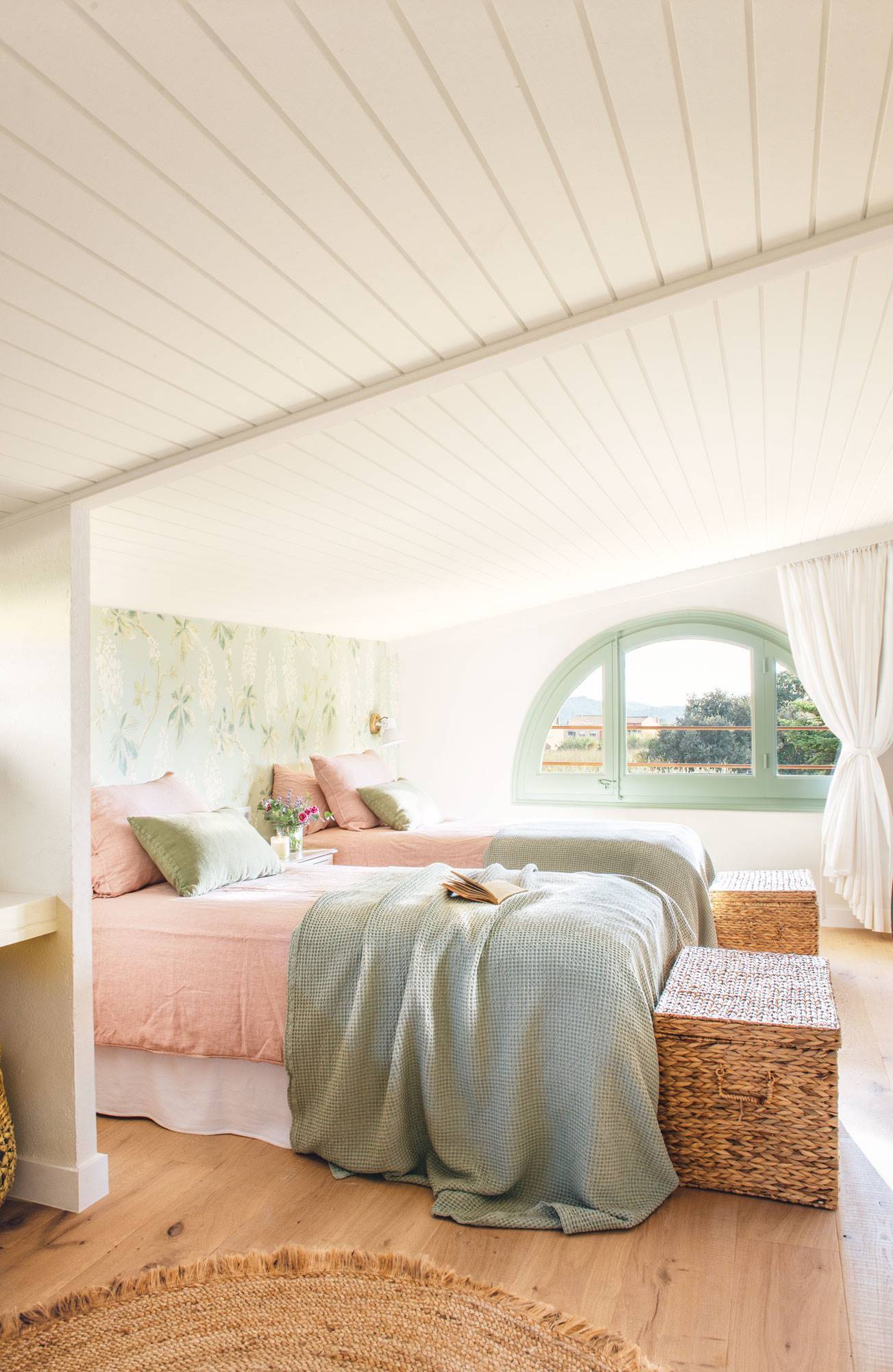 Dormitorio con el echo revestido de listones de madera en color blanco. 
