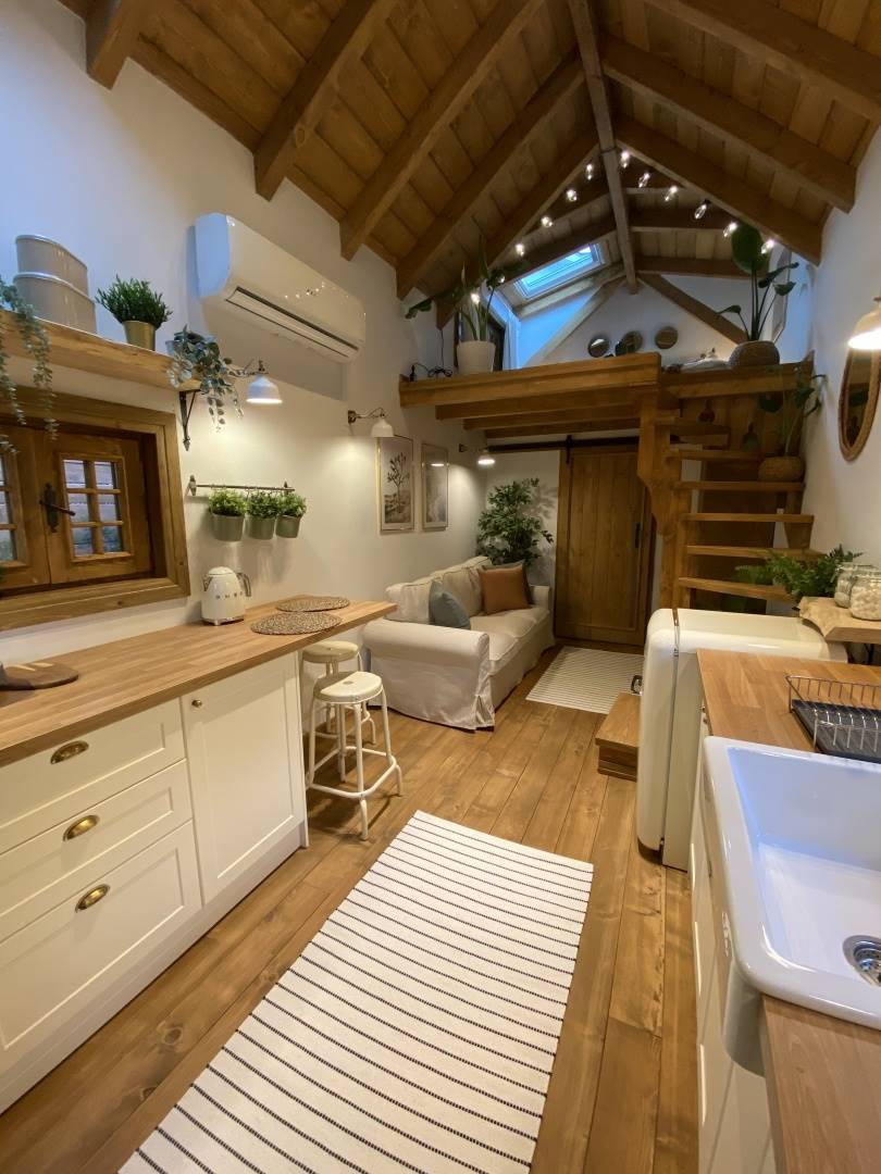 Una mini casa con cocina y salón en un mismo espacio.