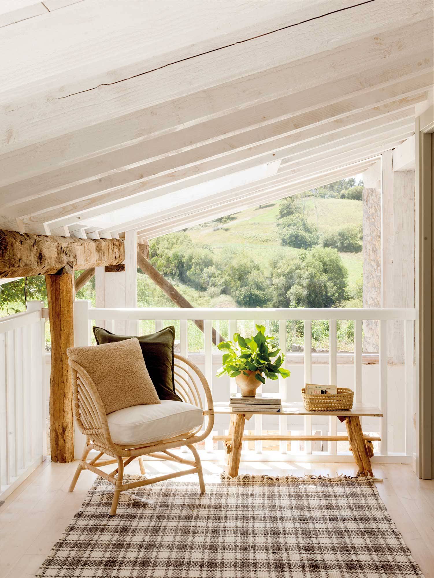 Terraza techada con sillón, banco y alfombra de cuadros.