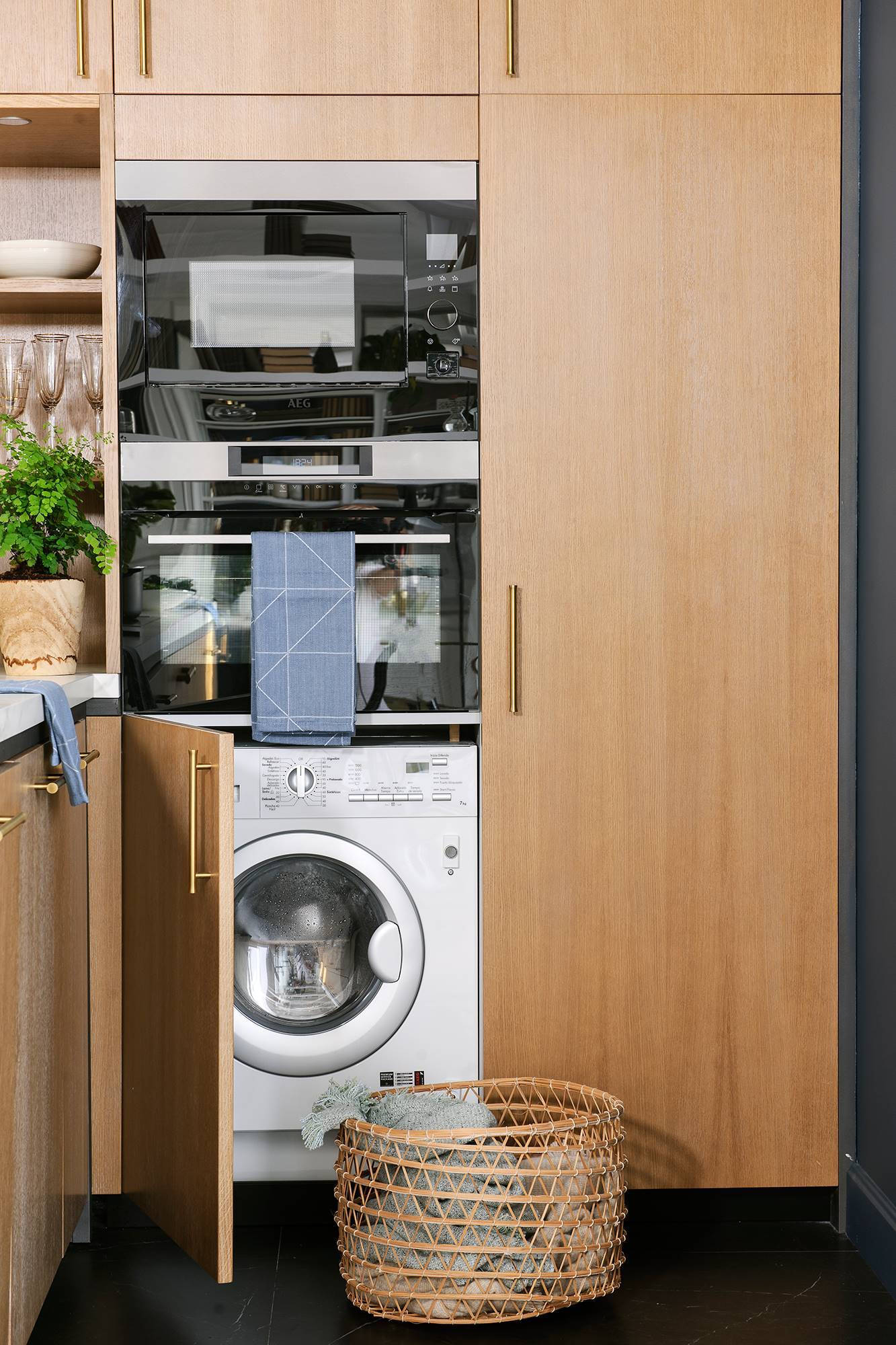 Cocina con electrodomésticos instalados en triple torre: lavadora + hornos.
