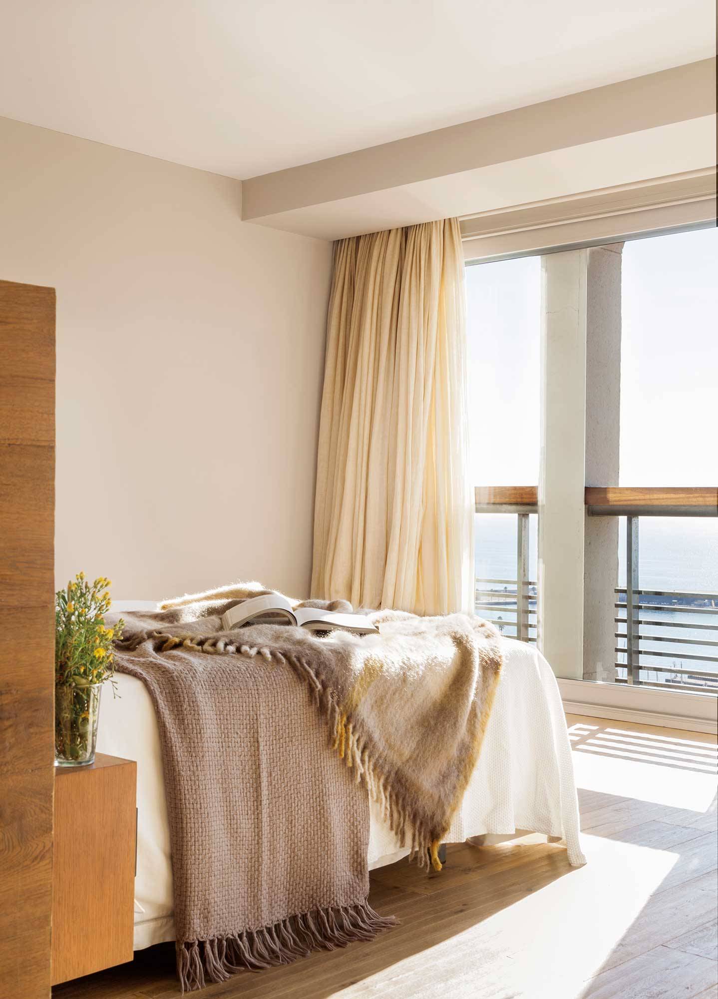 Dormitorio veraniego en color beige con cortinas hasta el techo.