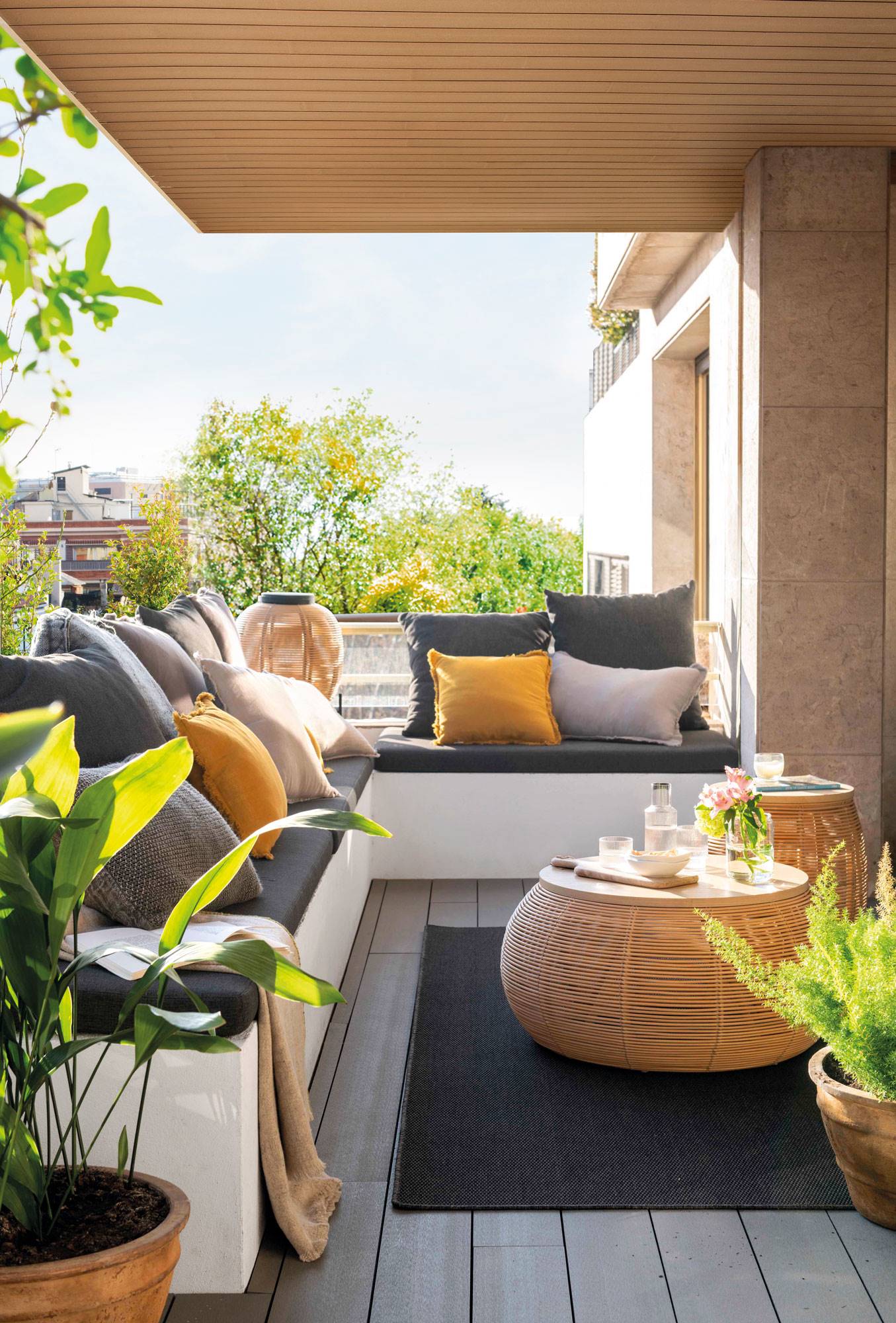 Una mini terraza en L en un balcón con zona chill out y estilo moderno. 