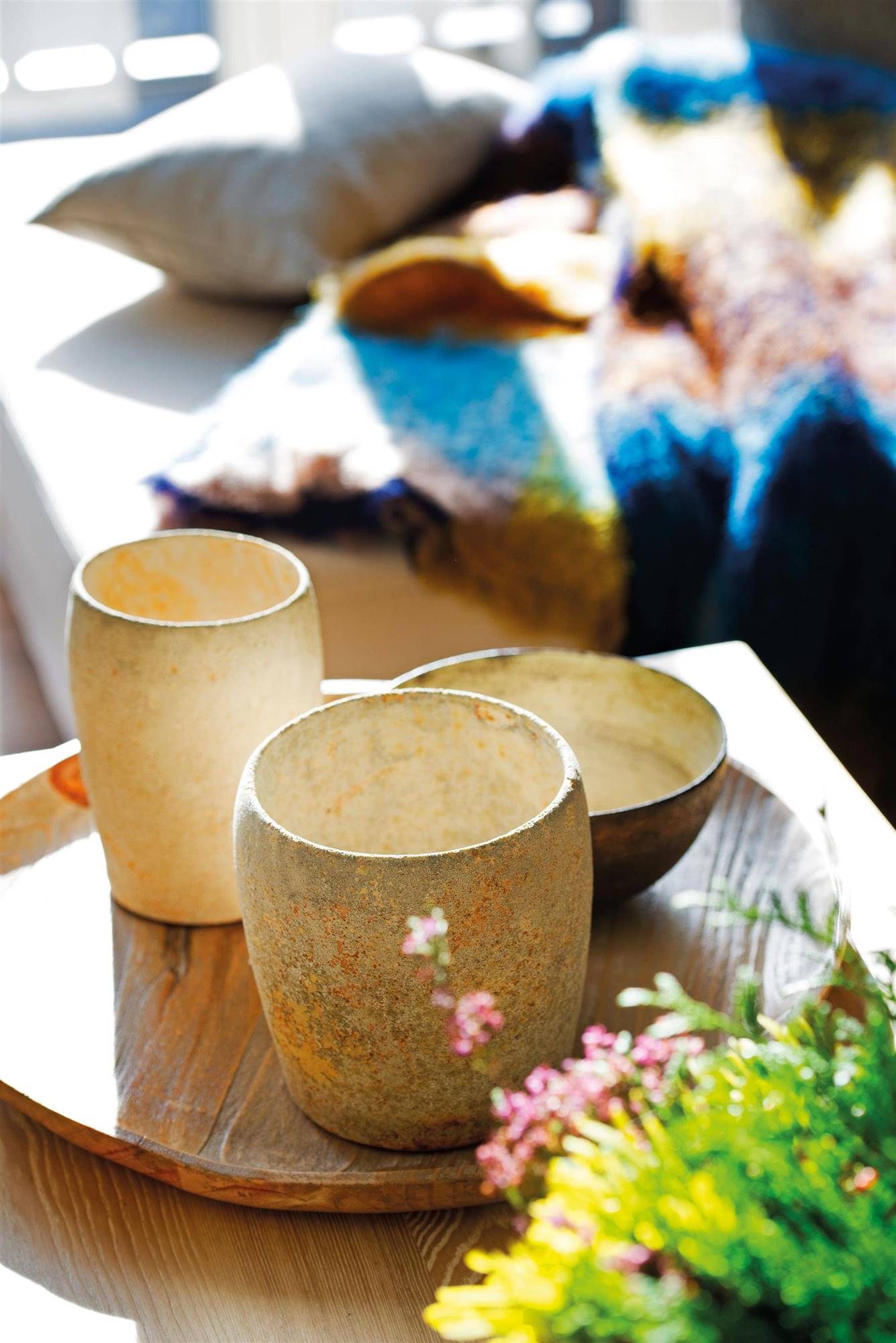 Vasijas de cerámica agrupadas en una bandeja de madera. 