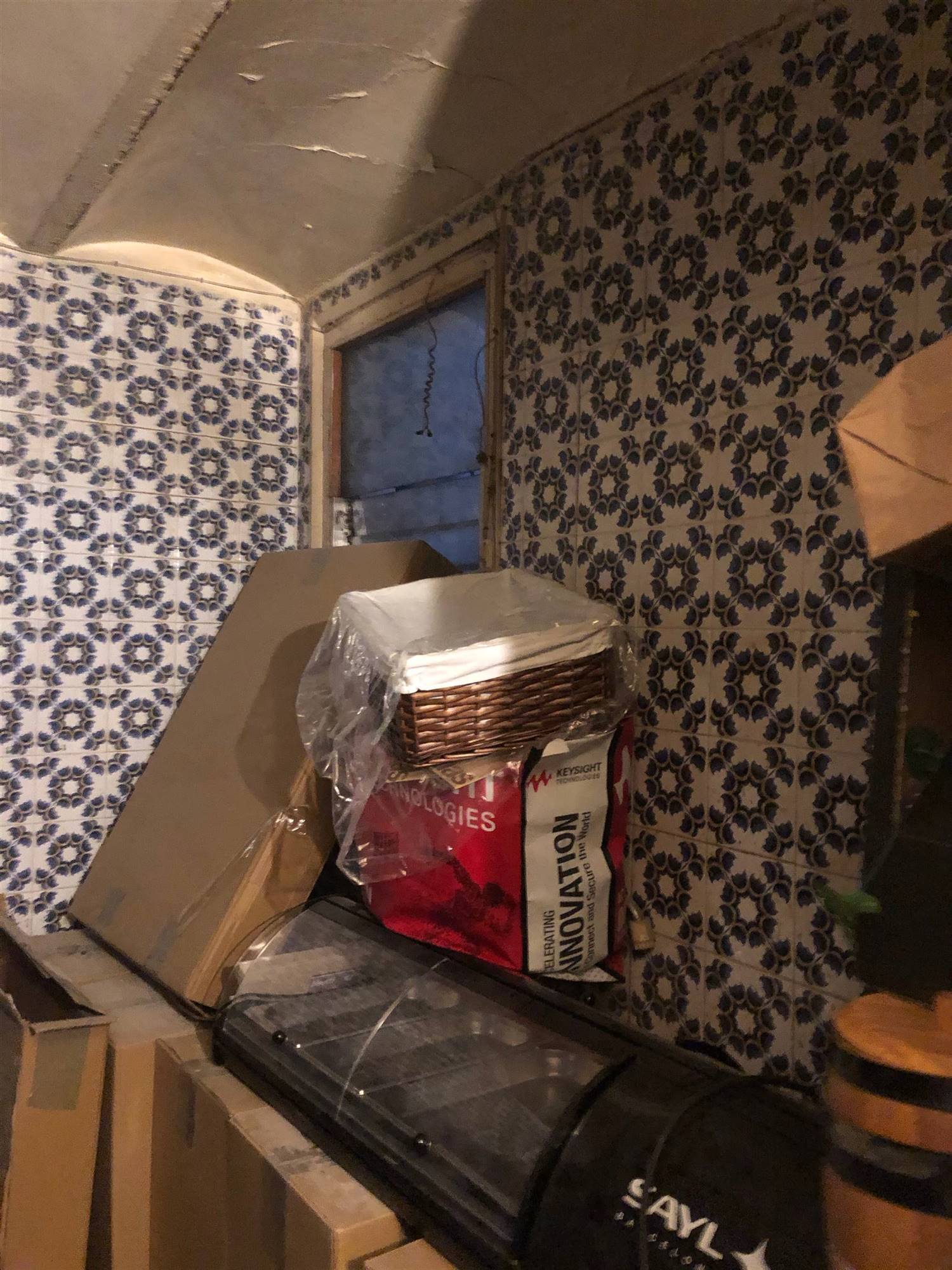 Un dormitorio con baldosines anticuados y un pequeño ventanal desaprovechado.
