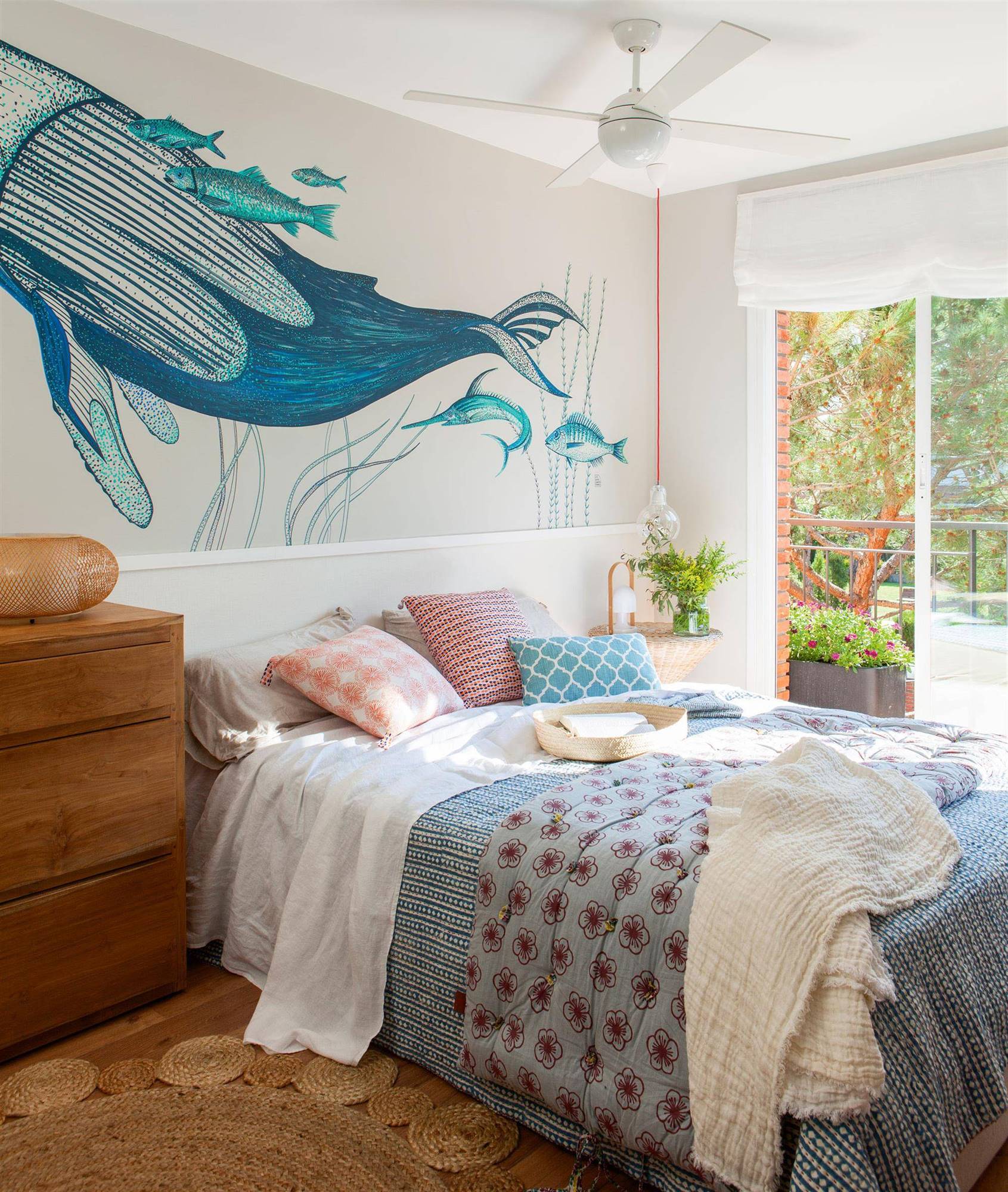 Dormitorio principal en blanco y azul  con pared del cabecero decorada con un mural pintado a mano.