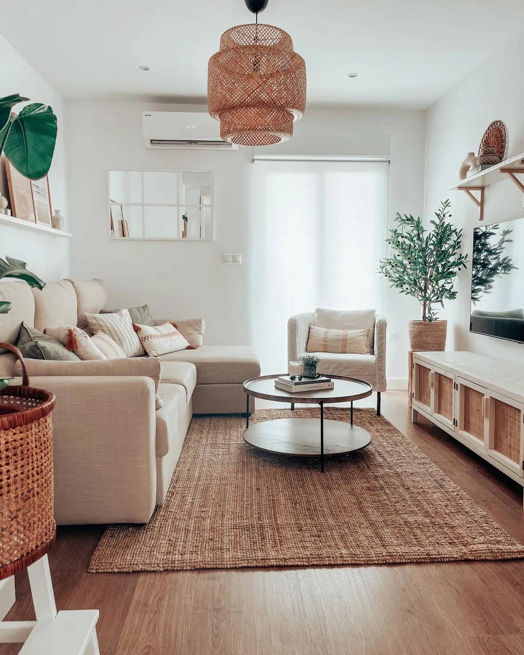 Salón de estilo natural con sofá con chaiselongue, alfombra de yute y estante de pared de IKEA.
