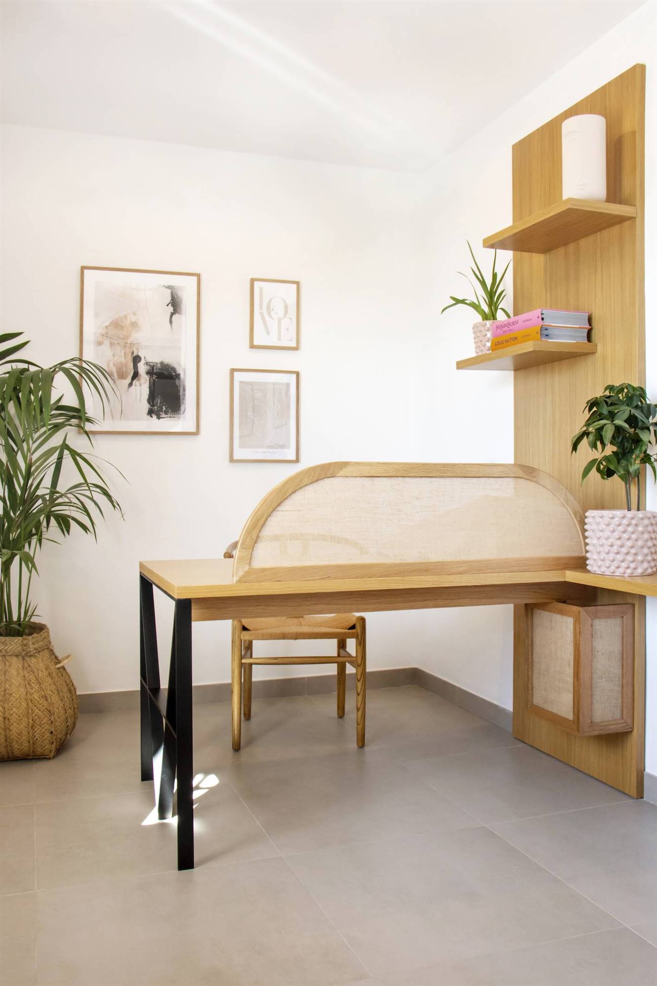 Un despacho con escritorio y estanterías de madera con plantas de interior. 
