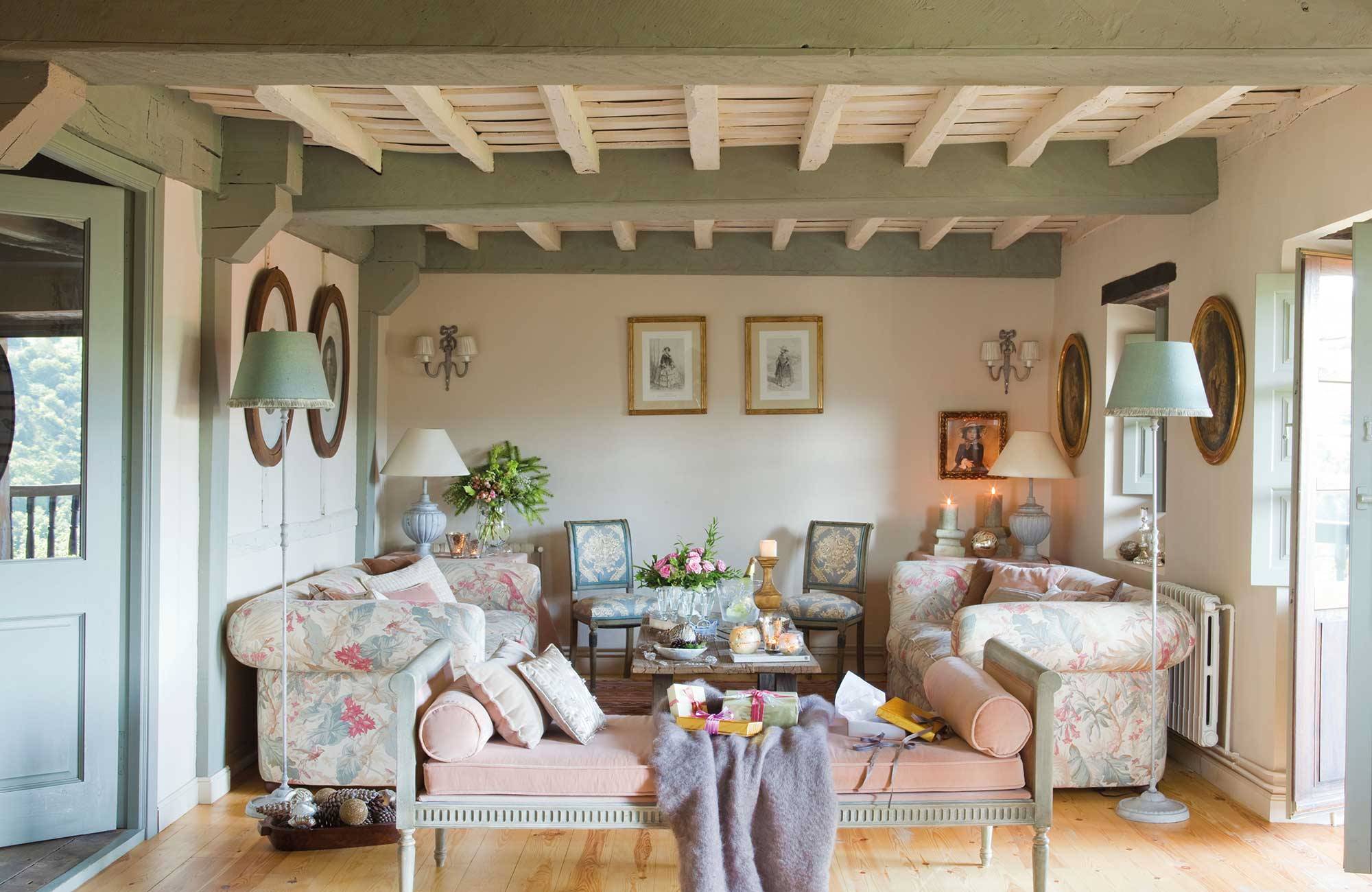 Salón vintage con sofás de flores y tonos deslavados.  