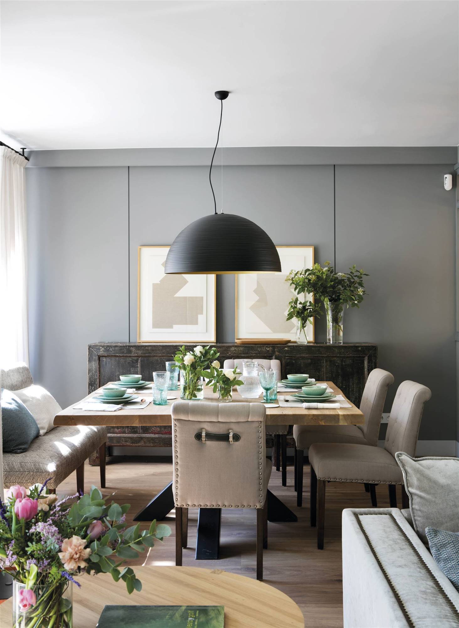 Comedor con pared color gris ceniza de estilo clásico y sillas tapizadas en gris. 