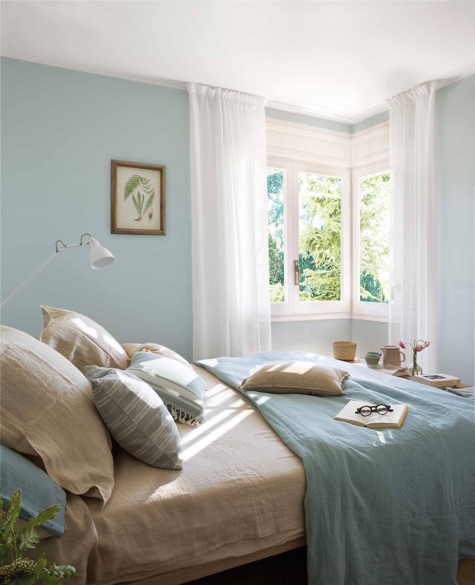 Dormitorio pequeño con paredes azul celeste. 
