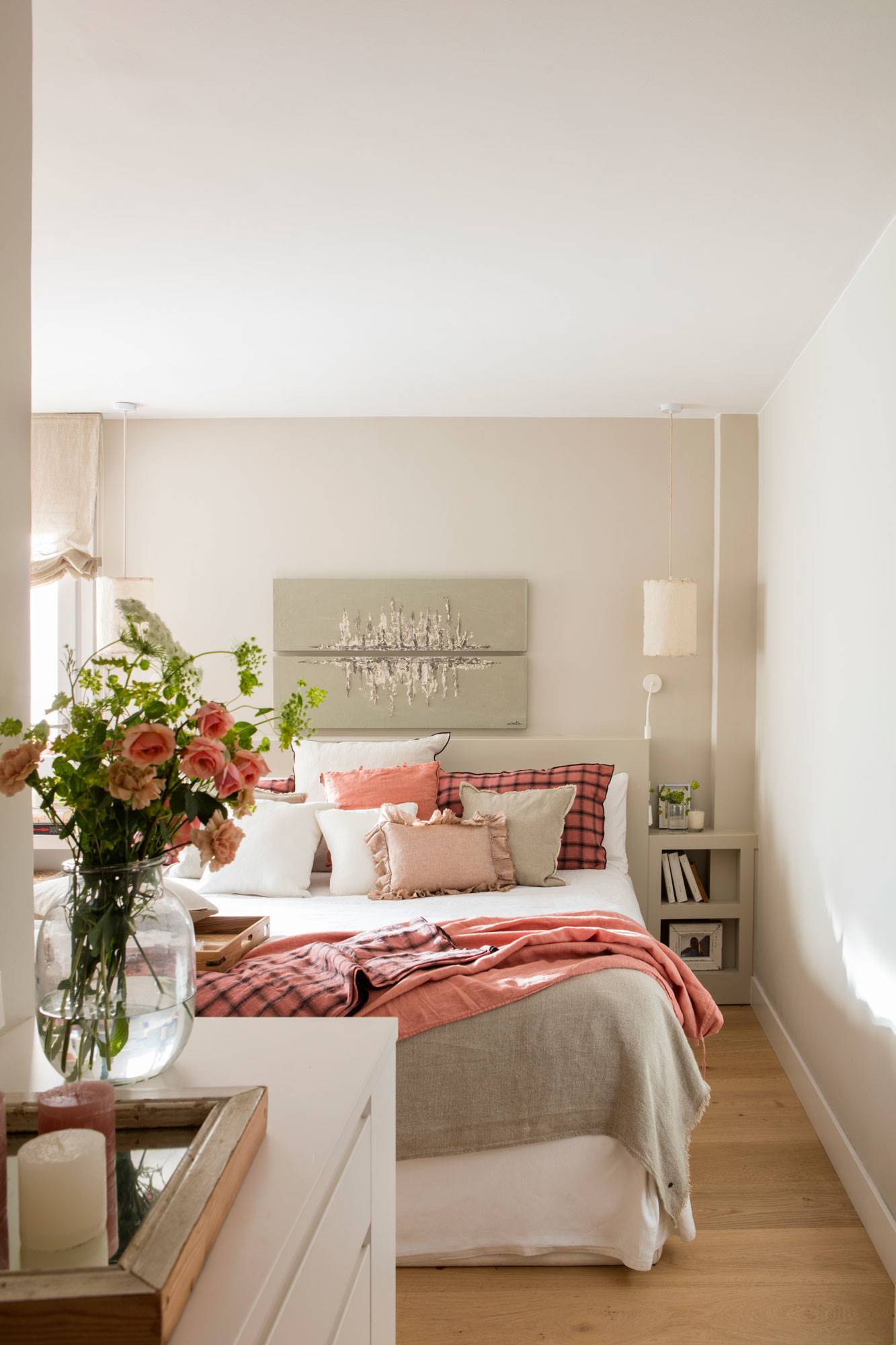 Dormitorio con paredes color beige y ropa de cama blanca y rosa. 