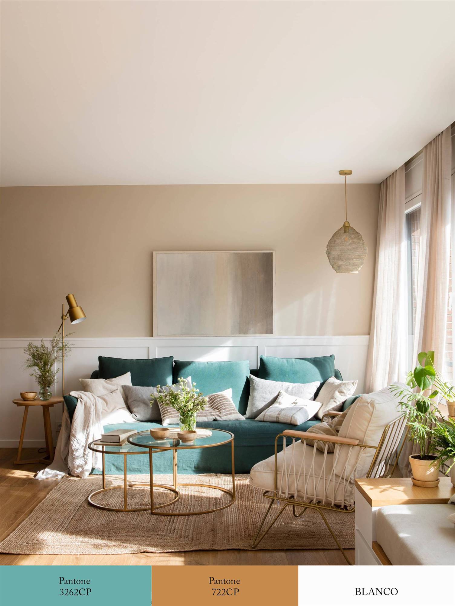 Salón con paredes con arrimadero blanco, sofá azul turquesa y detalles en dorado. 