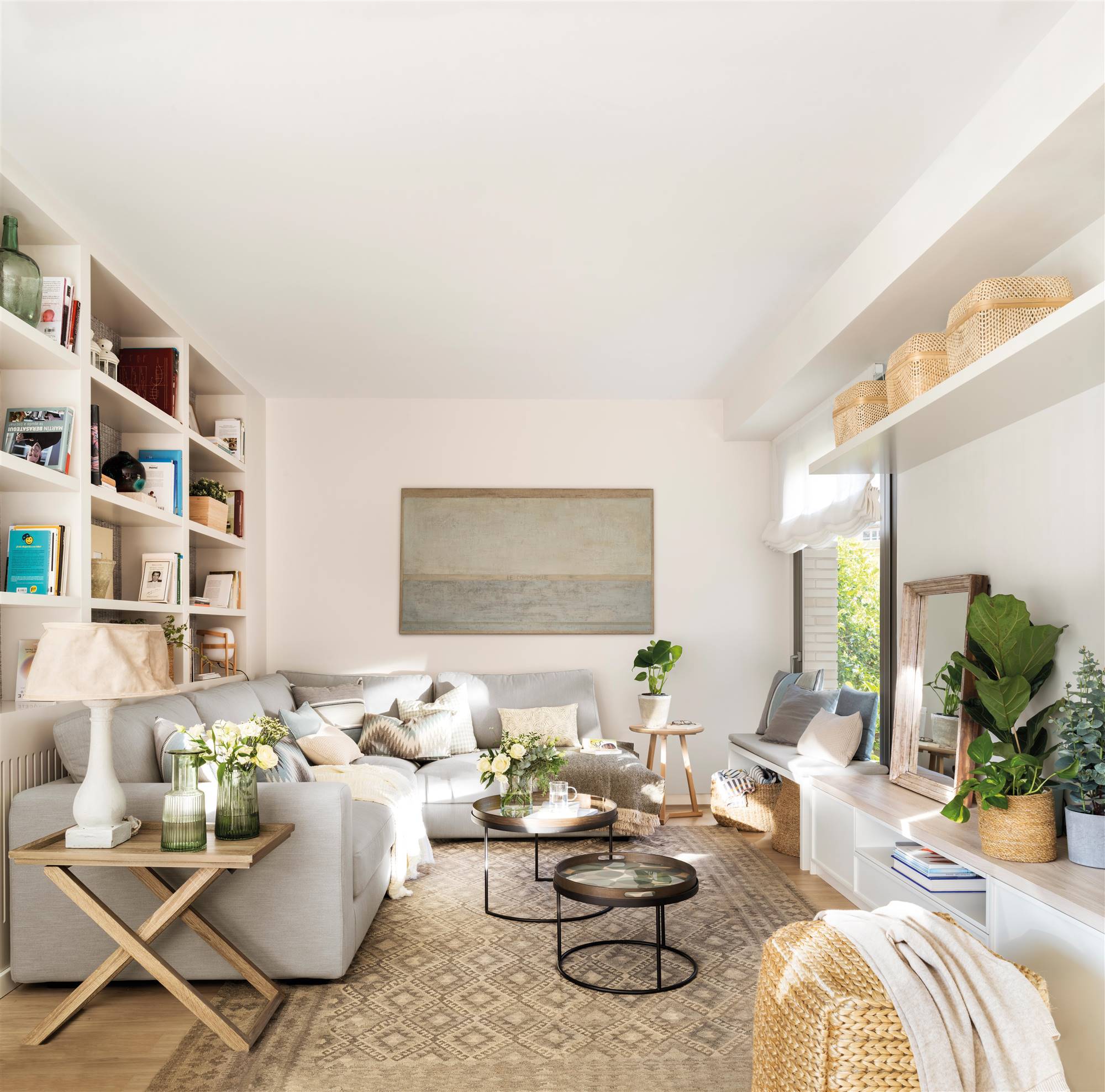 Salón con sofá rinconero de color gris y alfombra kilim en colores neutros. 