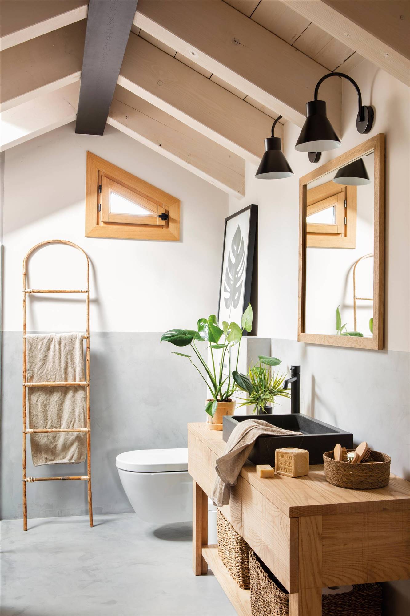Baño abuhadillado con las paredes lisas en dos colores y mueble de madera. 