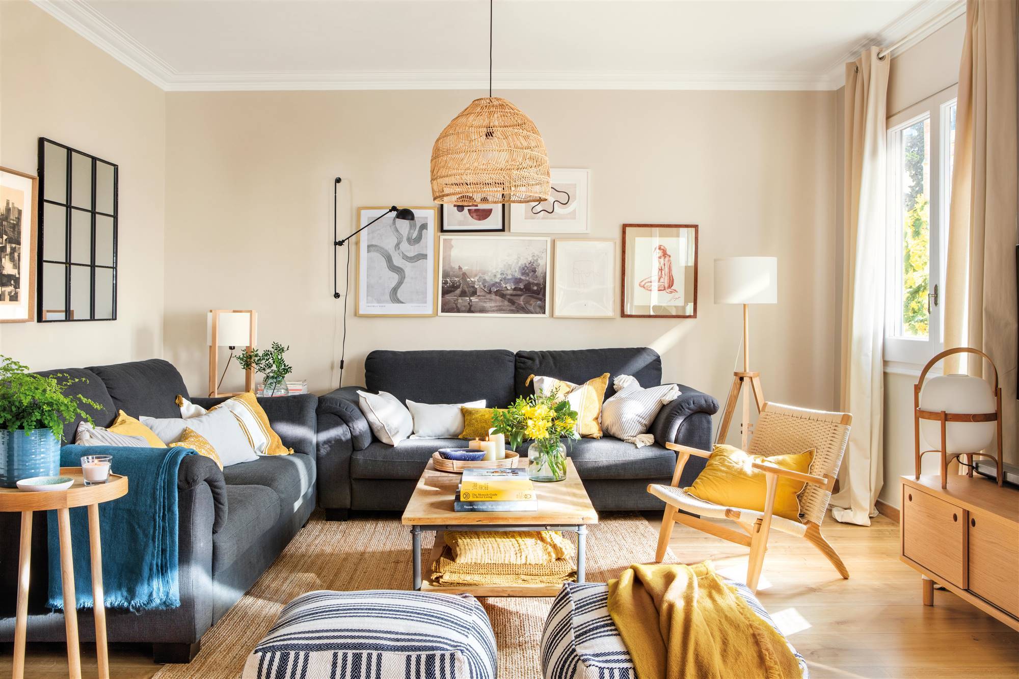 Salón con paredes beige, sofás grises y cojines blancos y mostaza. 