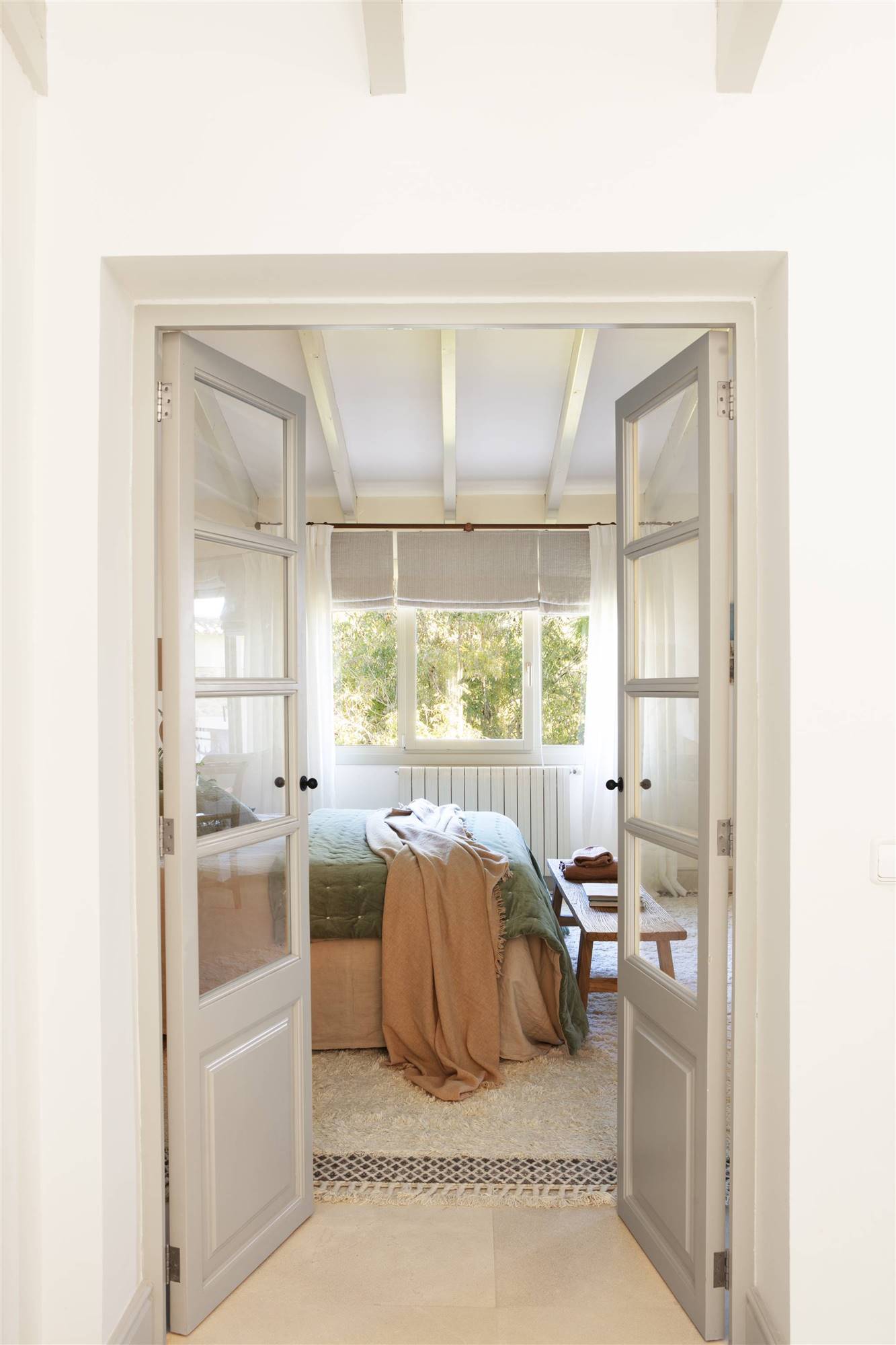 Dormitorio con alfombra de lana y puertas acristaladas. 