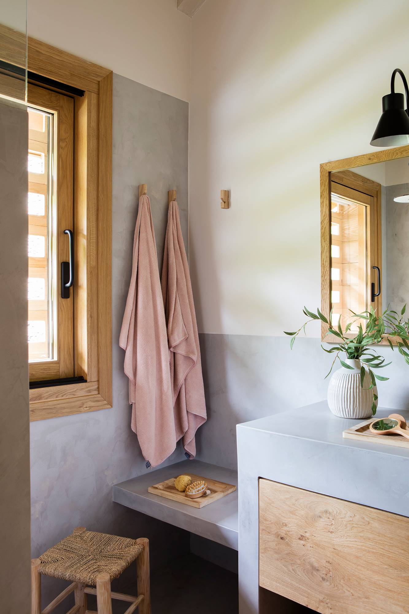 Baño organizado con perchas de pared para varias toallas. 