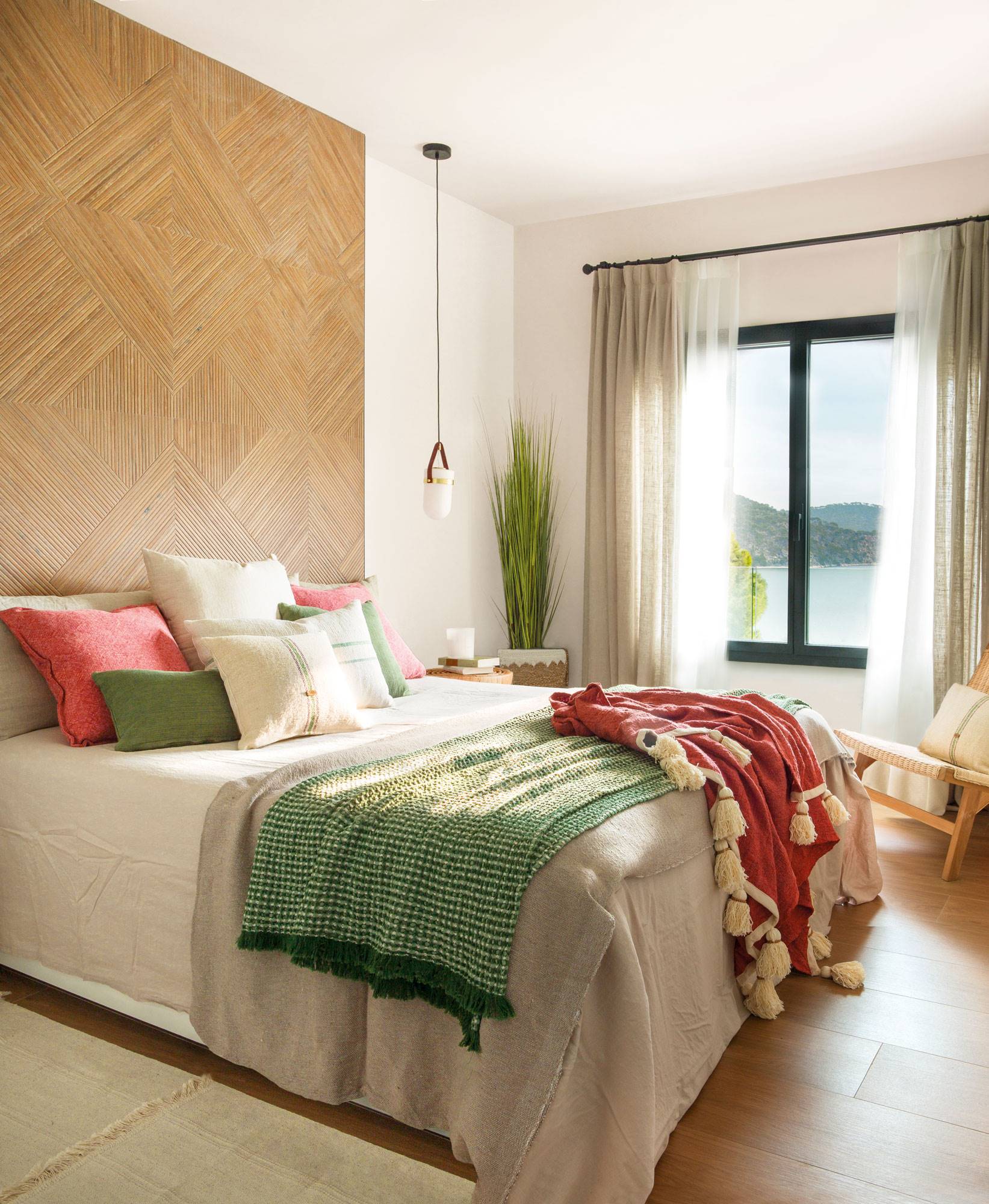 Dormitorio con cabecero revestido de baldosa que imita la madera.