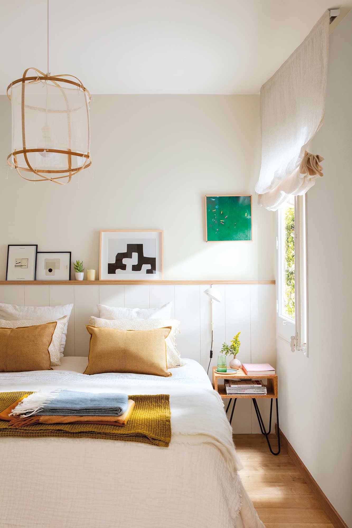 Dormitorio pequeño decorado en blanco con muebles de madera.