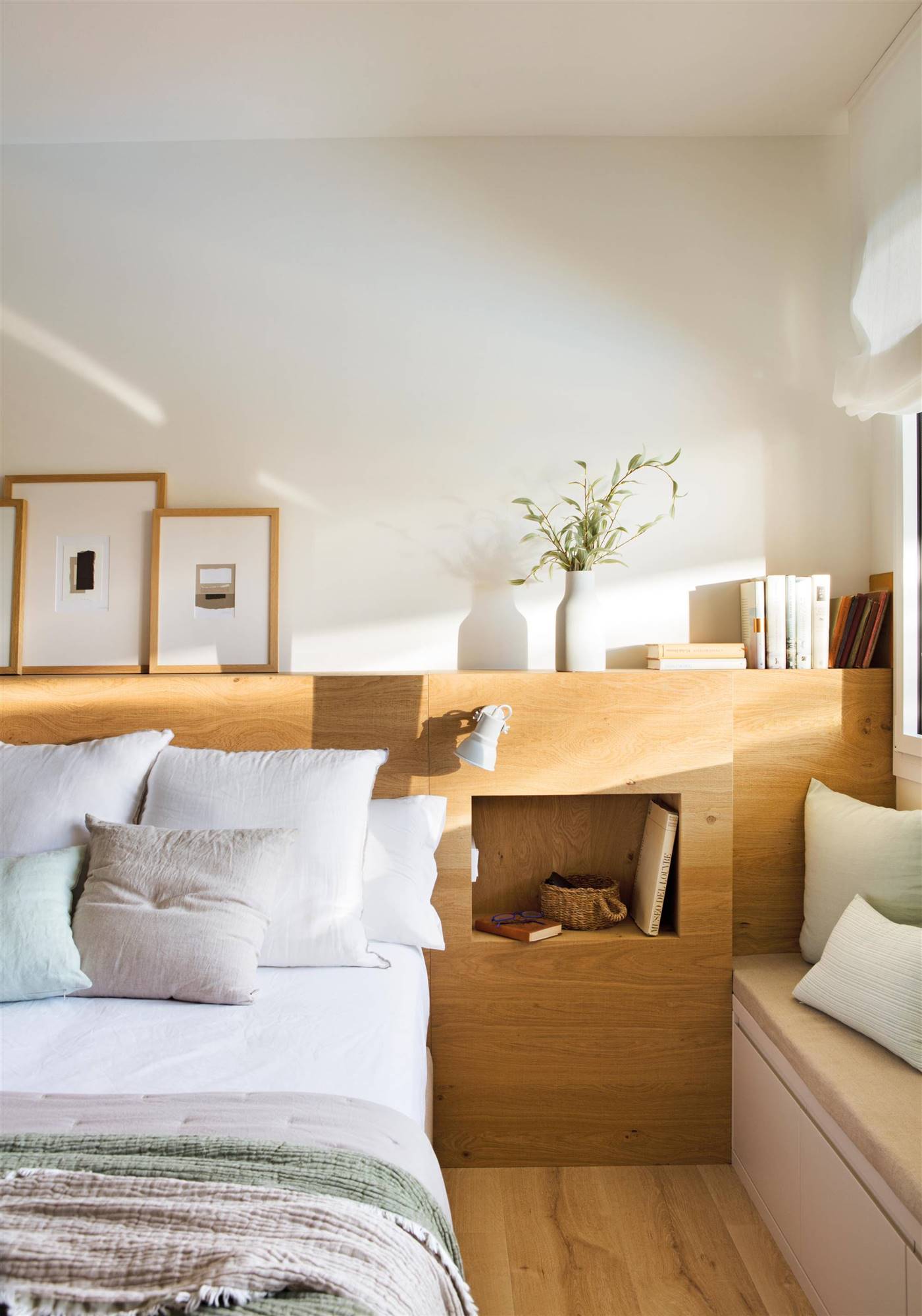 Dormitorio con cabecero de madera a medida con hornacinas como mesitas de noche.