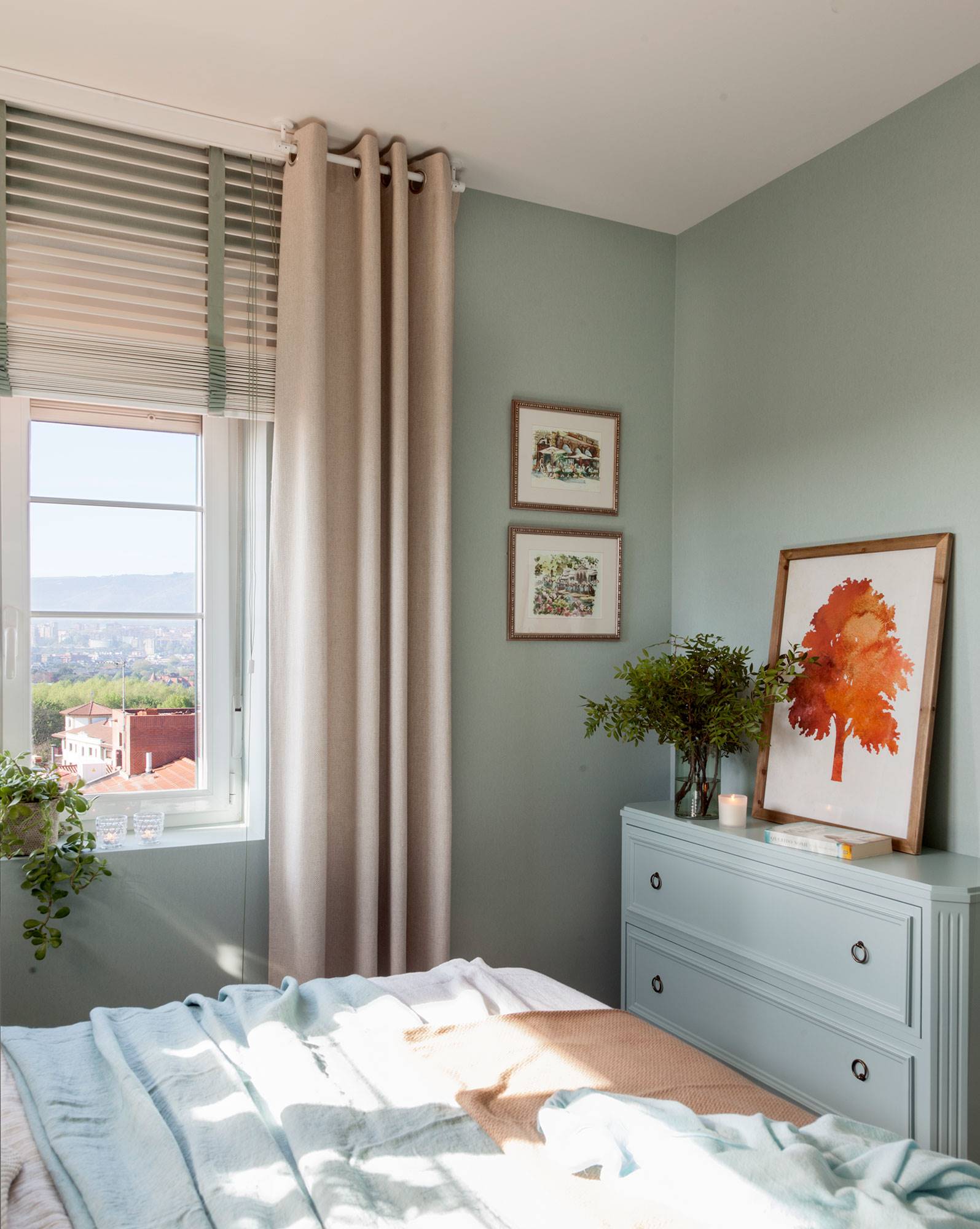 Dormitorio con cómoda pintada del mismo color que las paredes. 
