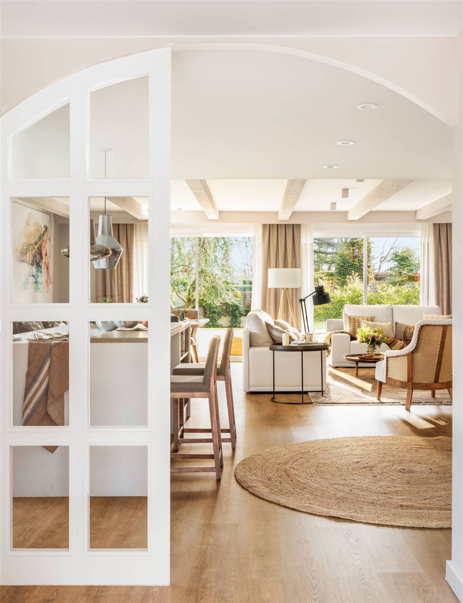 Salón abierto a la cocina con puerta fija blanca acristalada. 