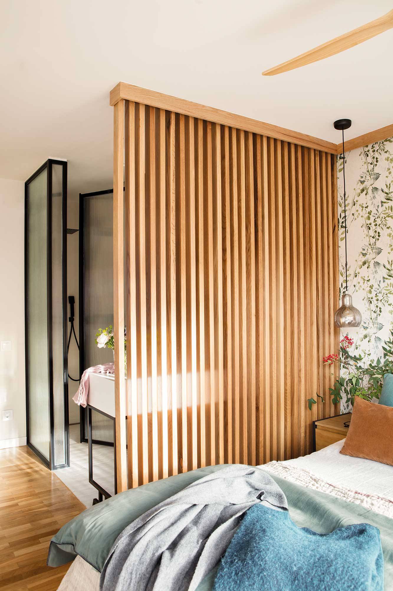 Dormitorio con celosía de madera que separa dormitorio y baño