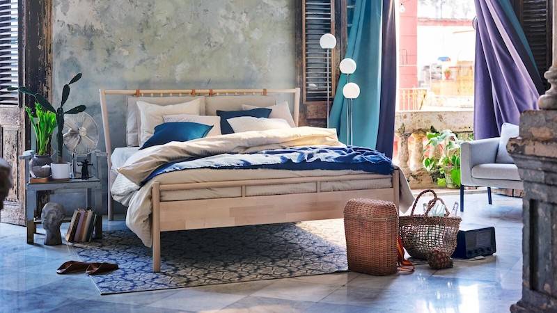 Dormitorio con cama doble de madera BJÖRKSNÄS de IKEA. 