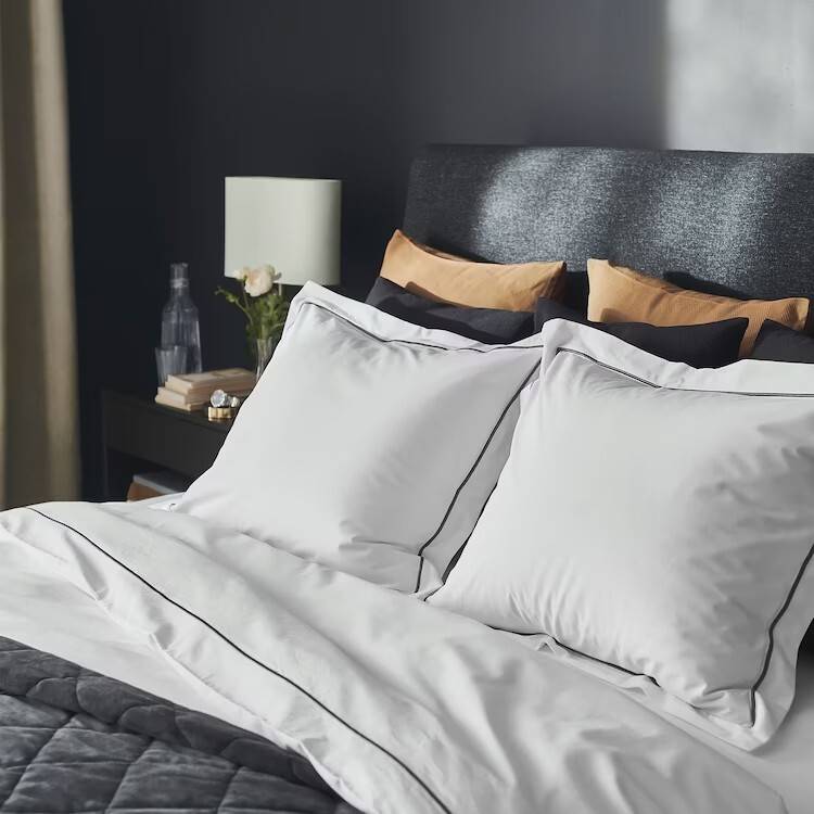 Funda nórdica con dos almohadas en blanco con cenefa gris SILVERTISTEL de IKEA.