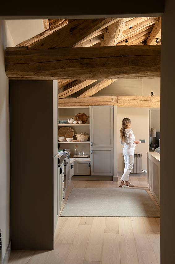 Cocina rehabilitada con techo de madera y vigas vistas