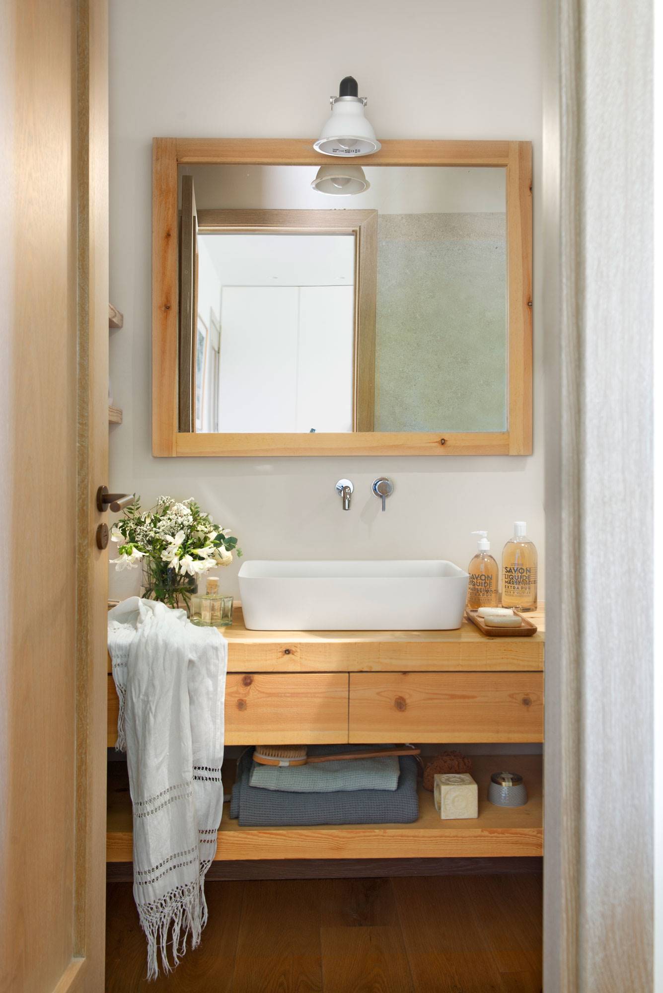 Baño con mueble y espejo de madera. 
