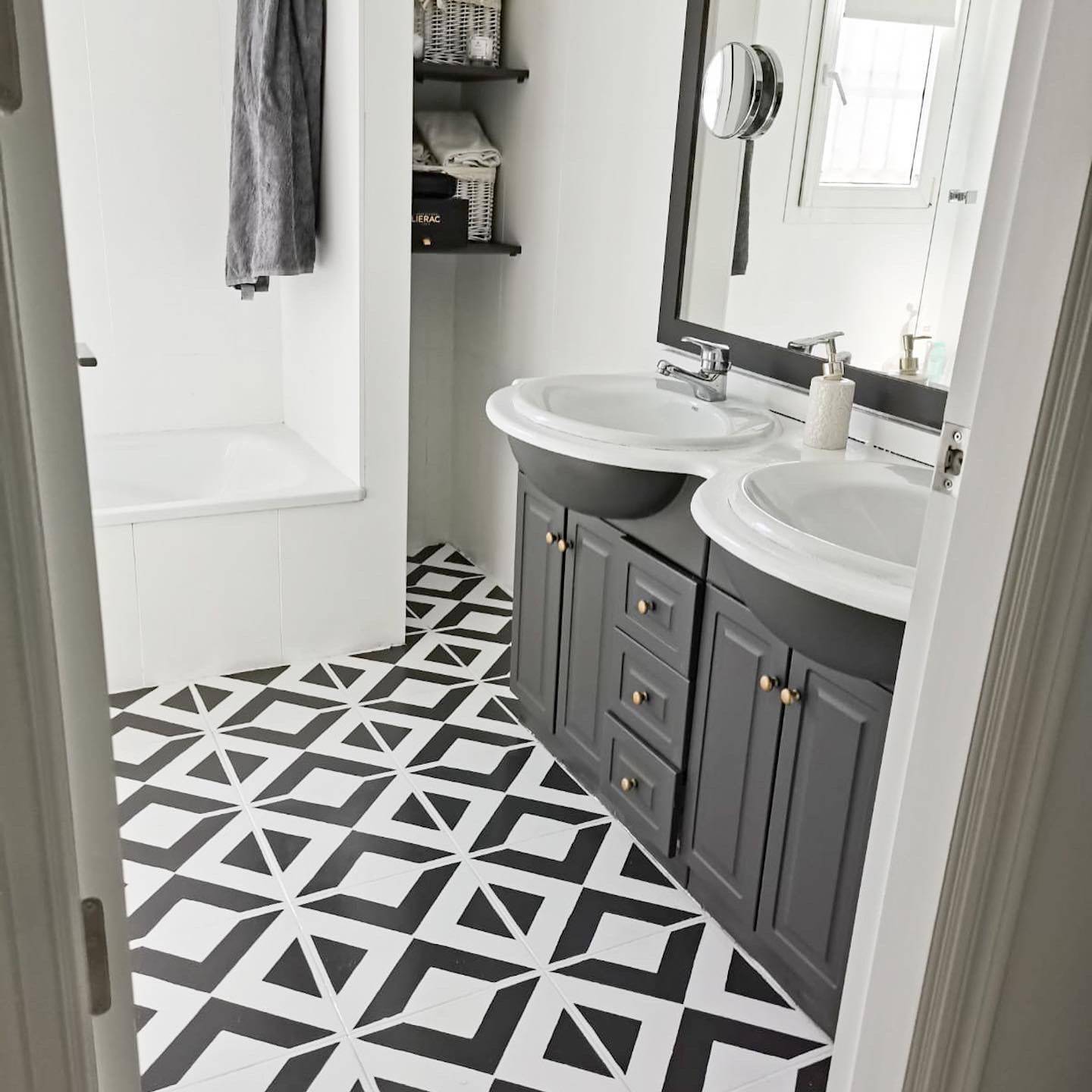 Baño con suelo pintado con pintura a la tiza en blanco y negro con dibujos geométricos.