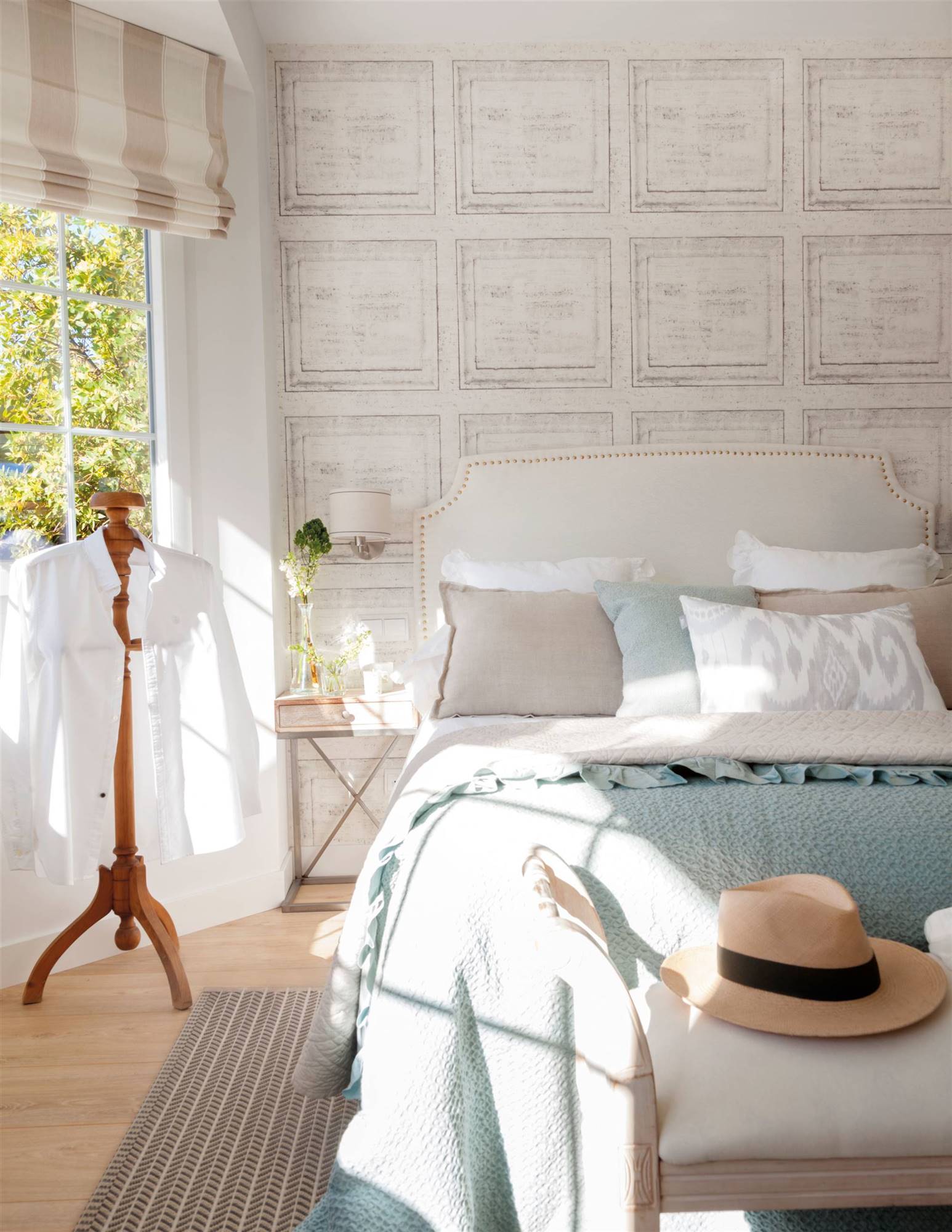 Dormitorio con pared cabecero con papel pintado que simula cuadros. 