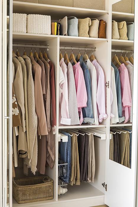 Un armario lleno de ropa ordenada.