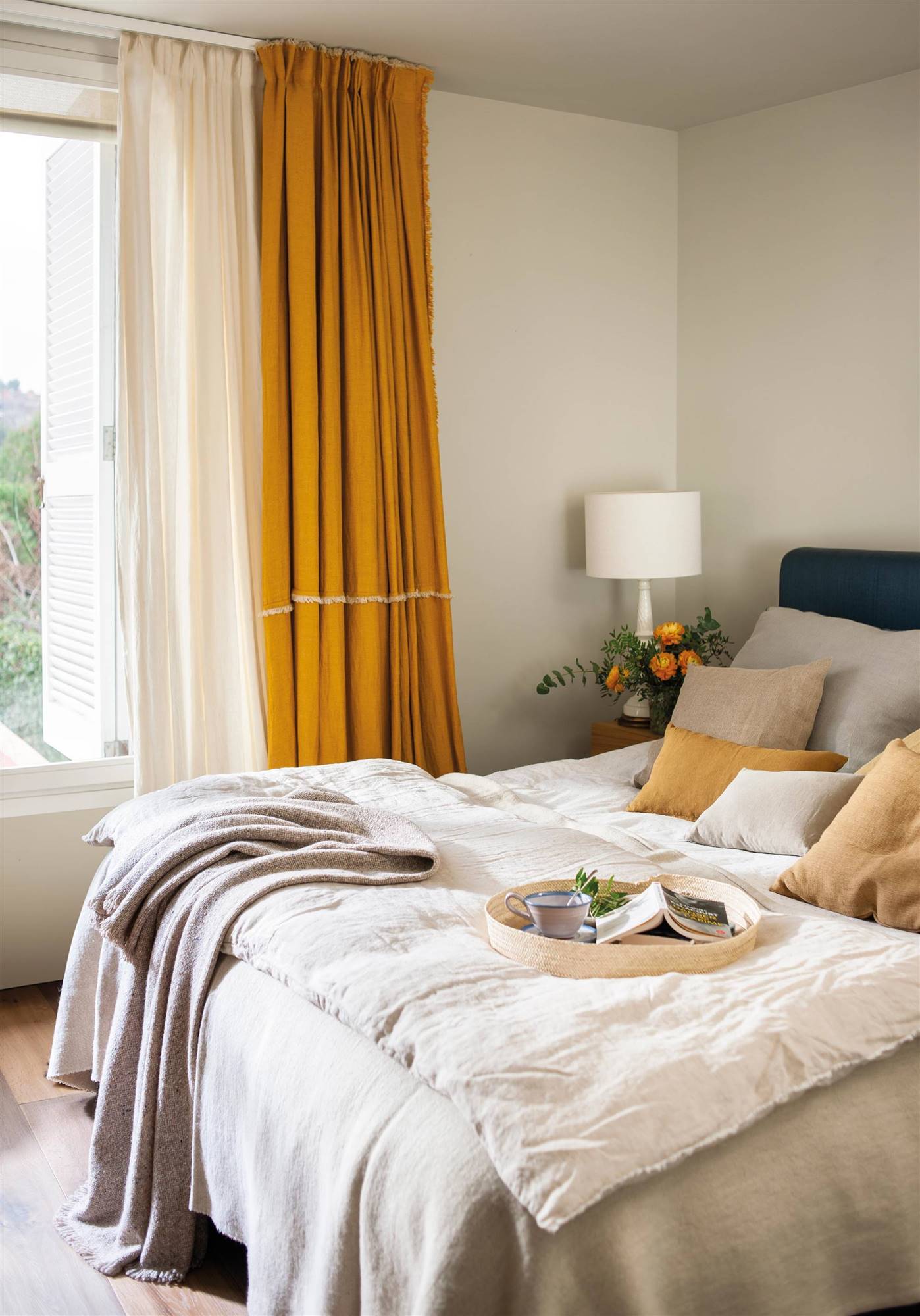 Dormitorio con cortinas de lino en color mostaza.