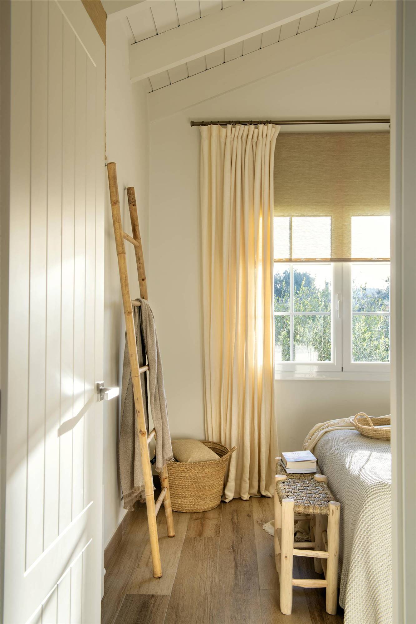 Dormitorio con cortinas livianas en colores claros y escalera decorativa en pared.