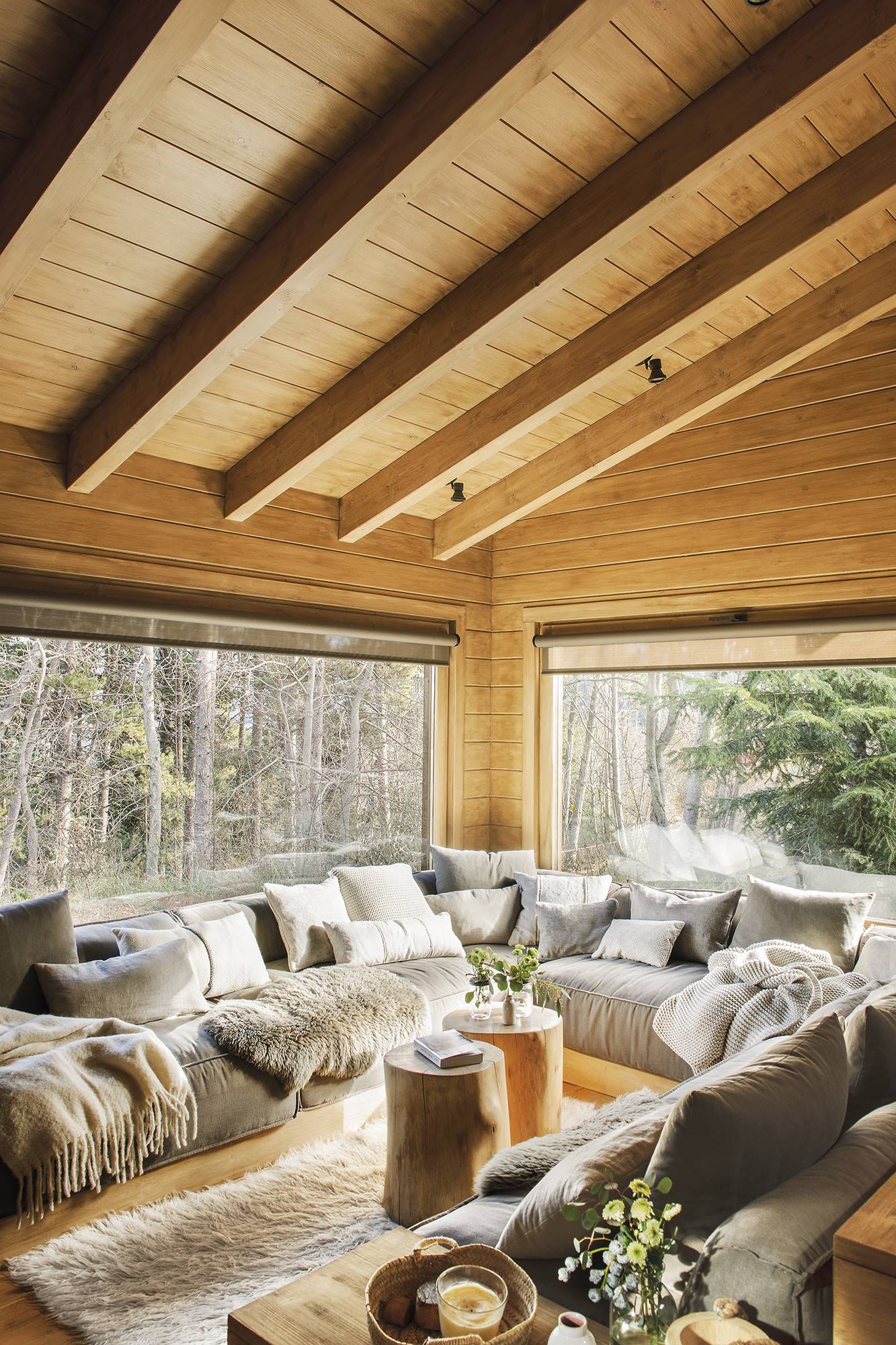 Salón rústico revestido en madera con sofá en U. 