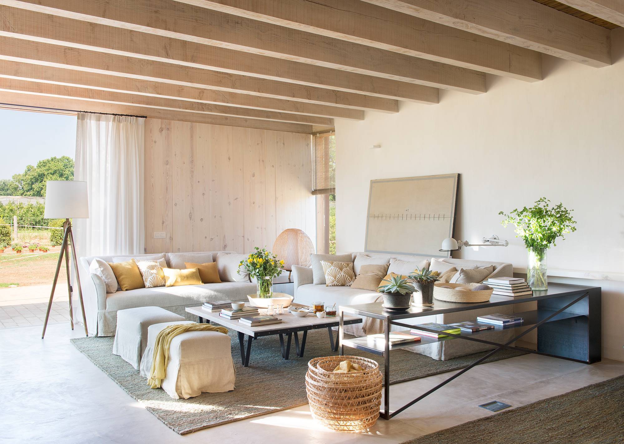 Salón minimalista con dos sofás en forma de L y mesas de hierro
