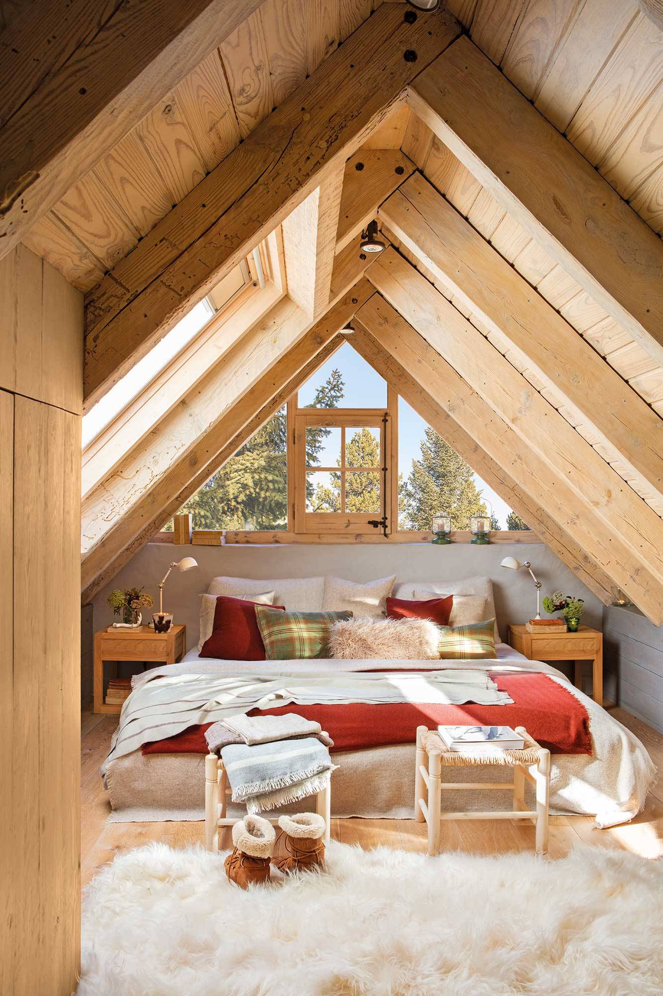 Dormitorio de otoño en buhardilla revestida de madera de una casa de montaña