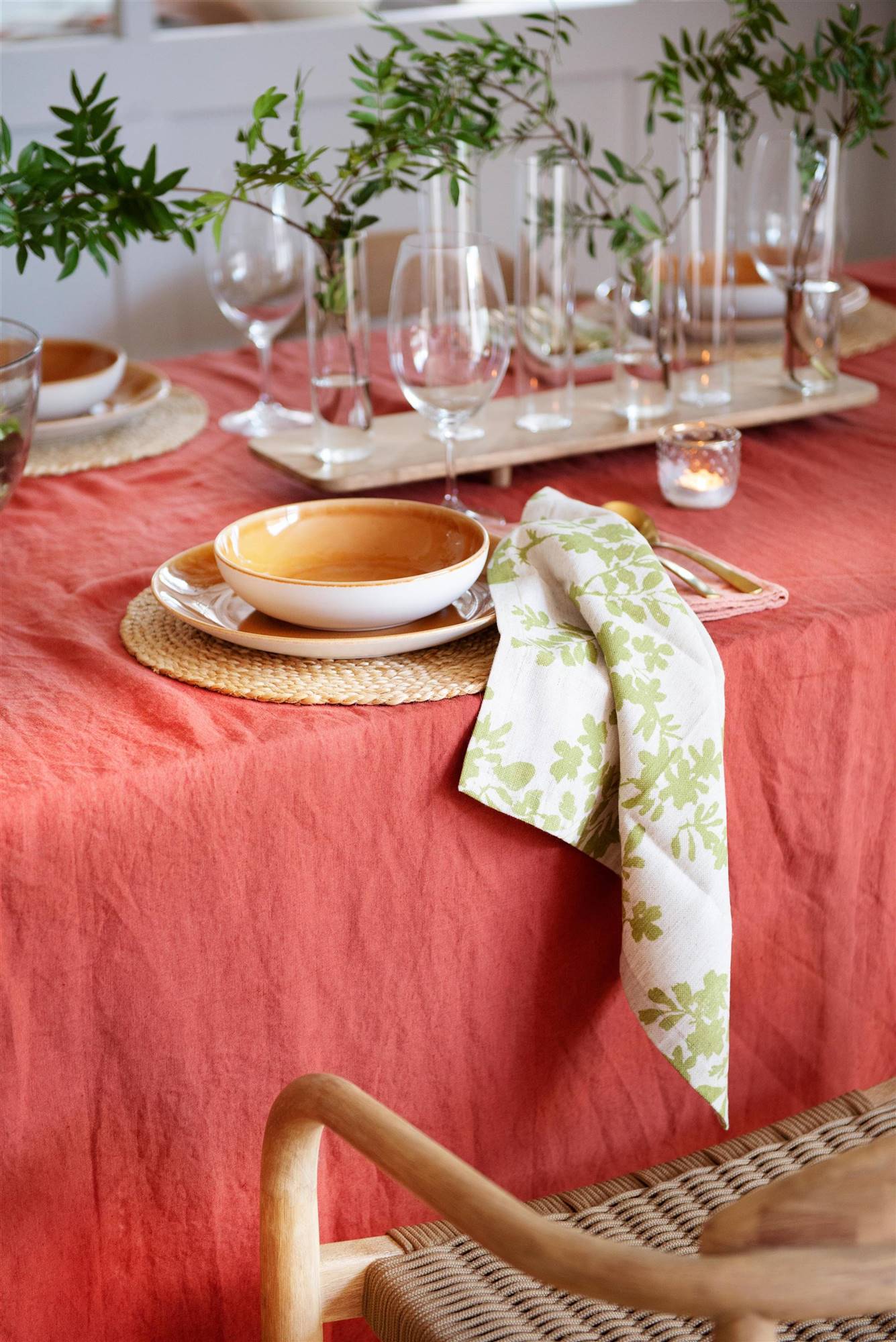 Mantel de lino en color rojizo y vajilla en tonos tierra para vestir la mesa de comedor.